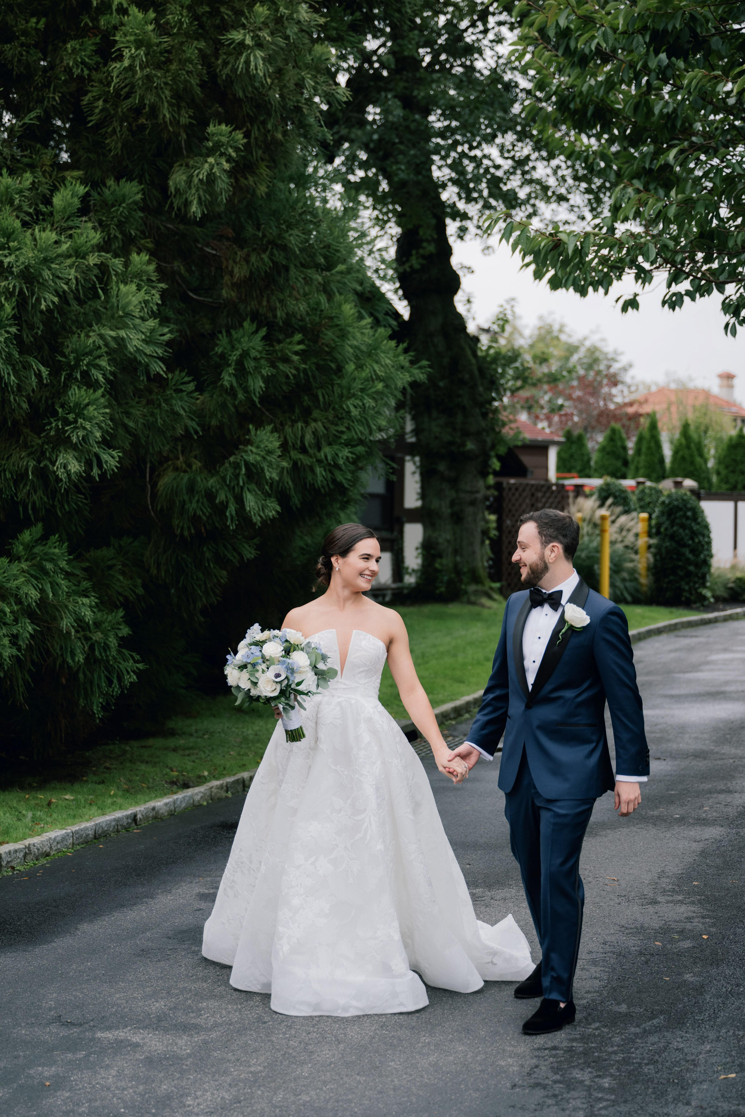 a bride and groom walking down the road