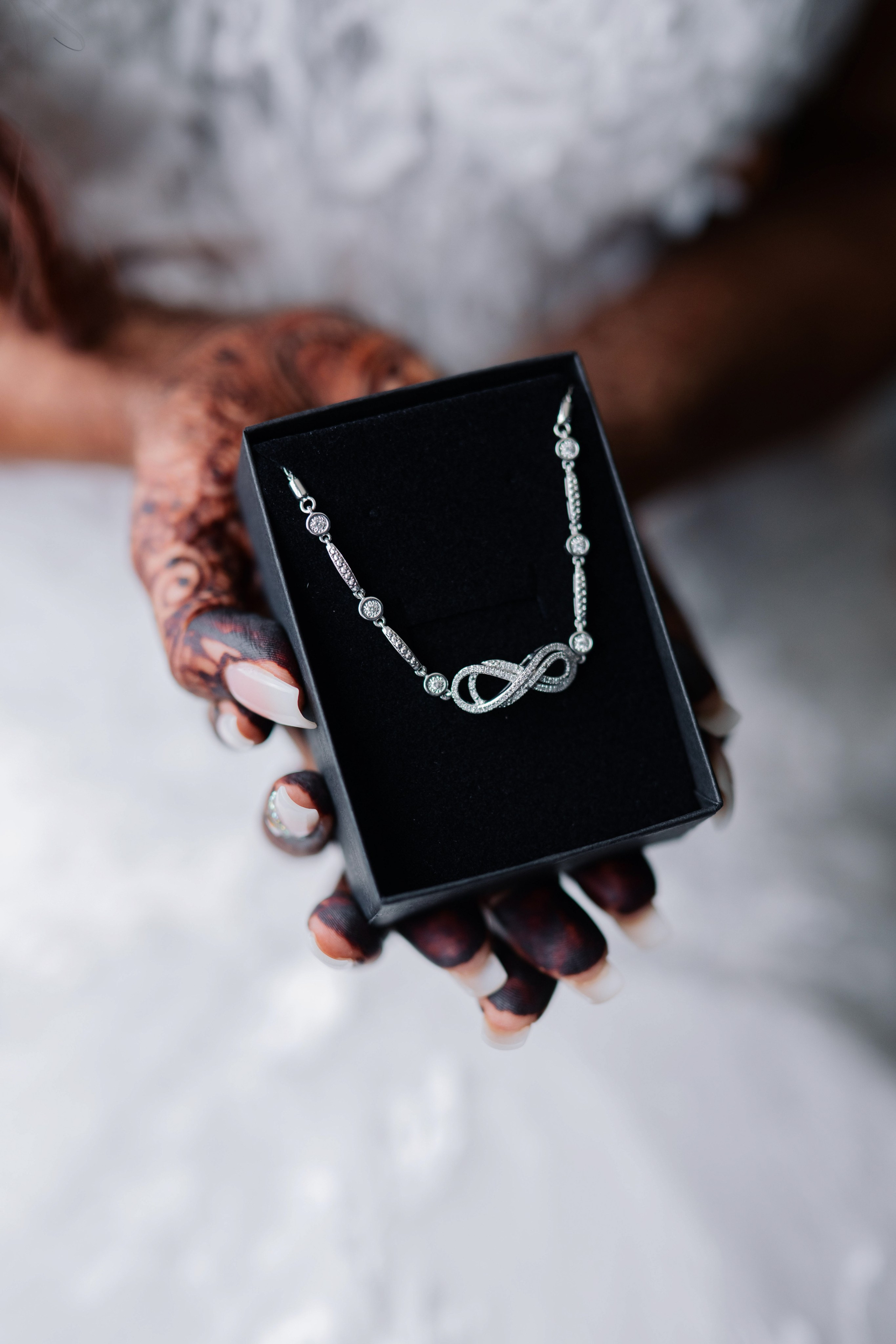 a woman holding a black box with a necklace