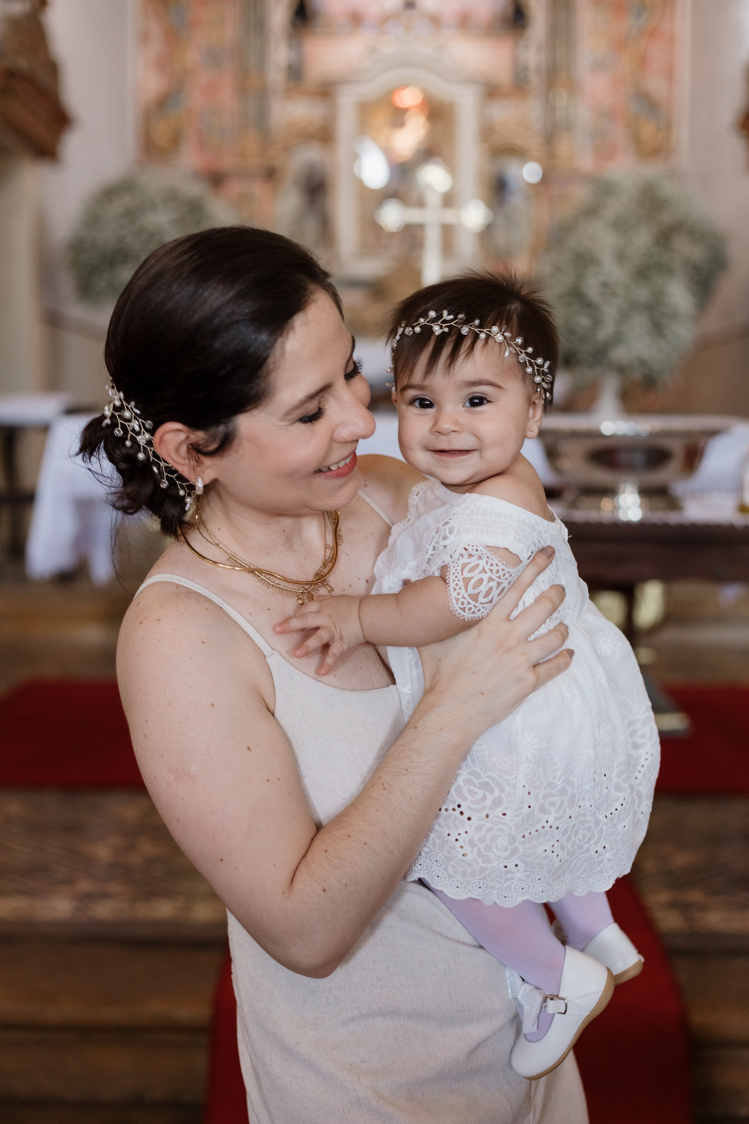 Mãe e filha em momento descontraído antes da cerimônia do batismo