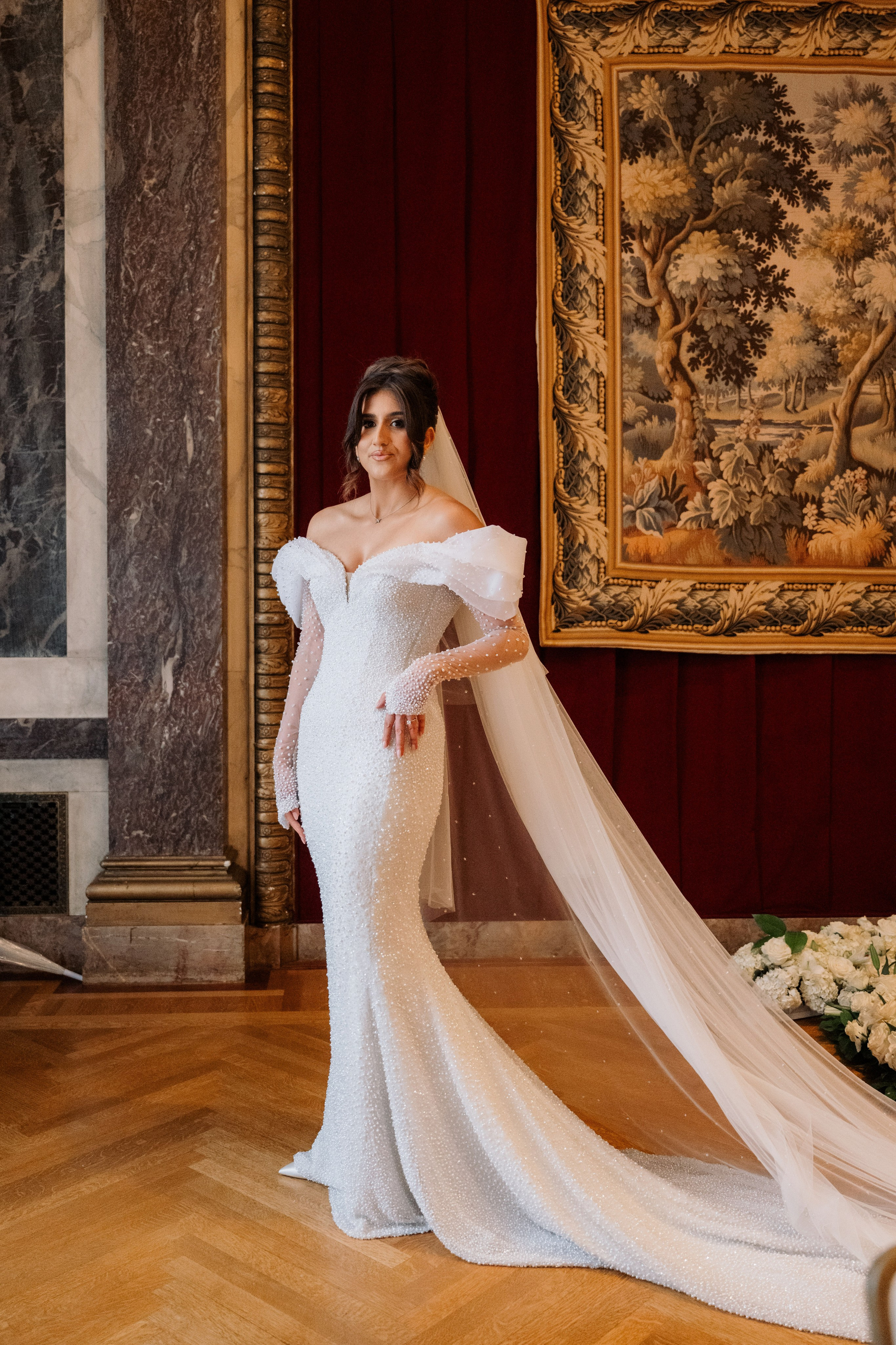 a woman in a wedding dress standing in front of a painting