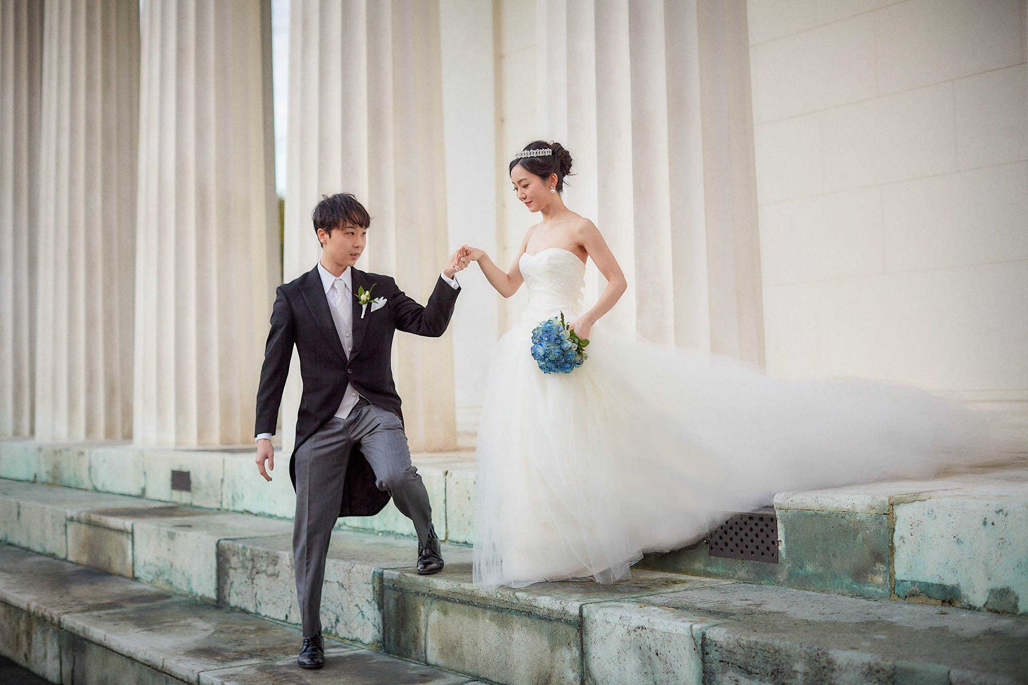 Groom leading bride down stairs in Volksgarten Vienna.