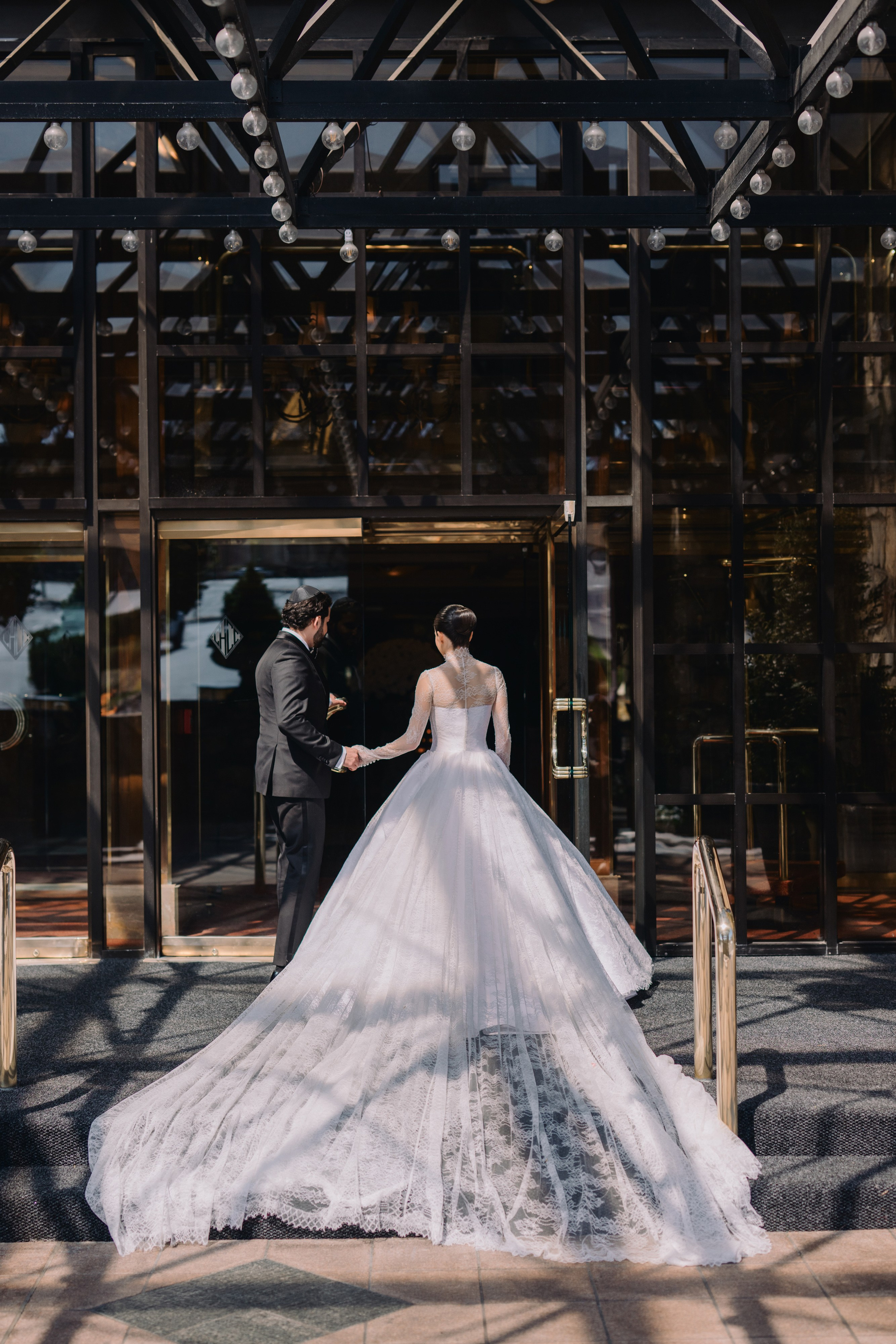 a bride and groom standing in front of a glass building