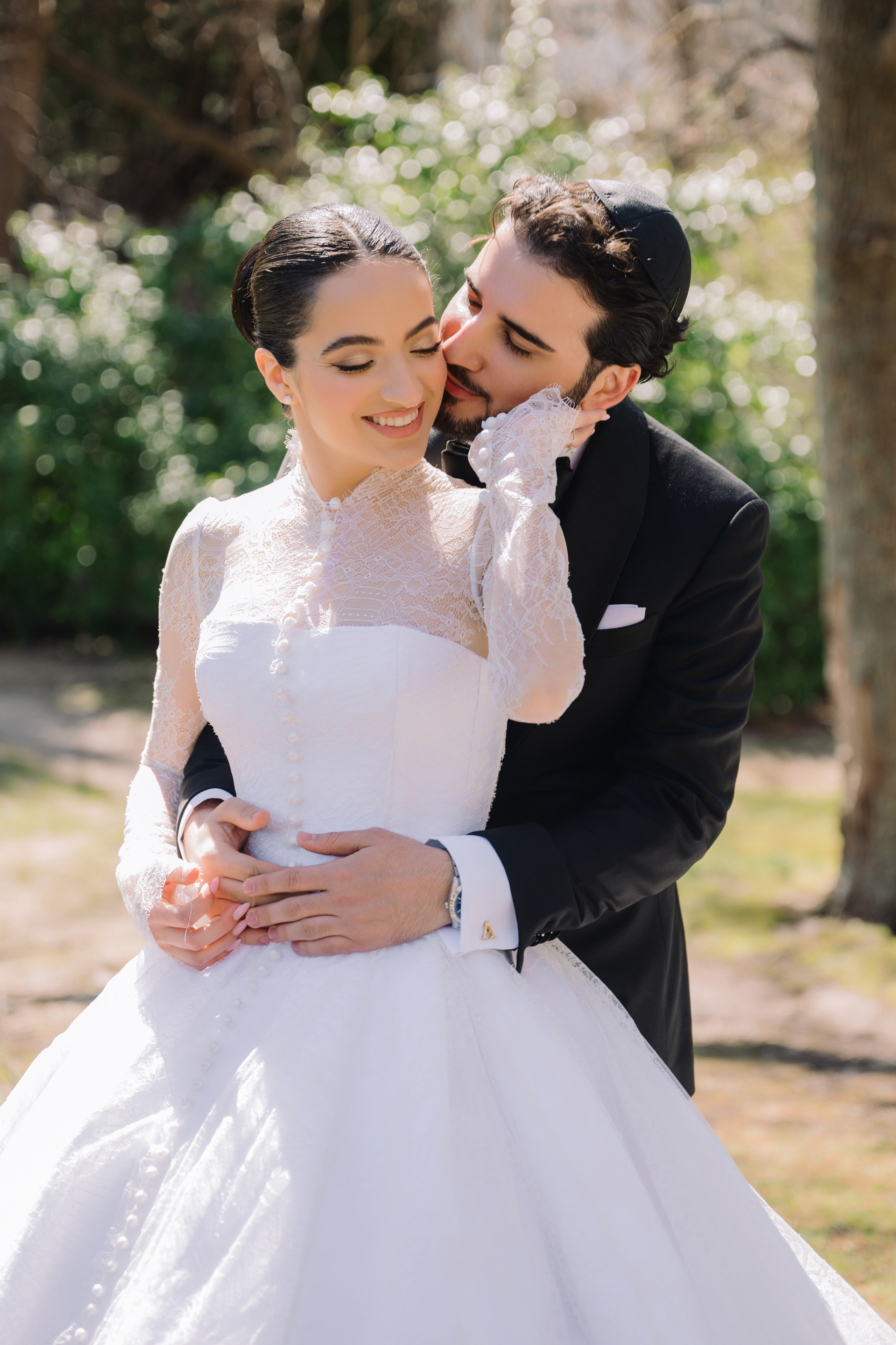 a bride and groom pose for a photo in the park