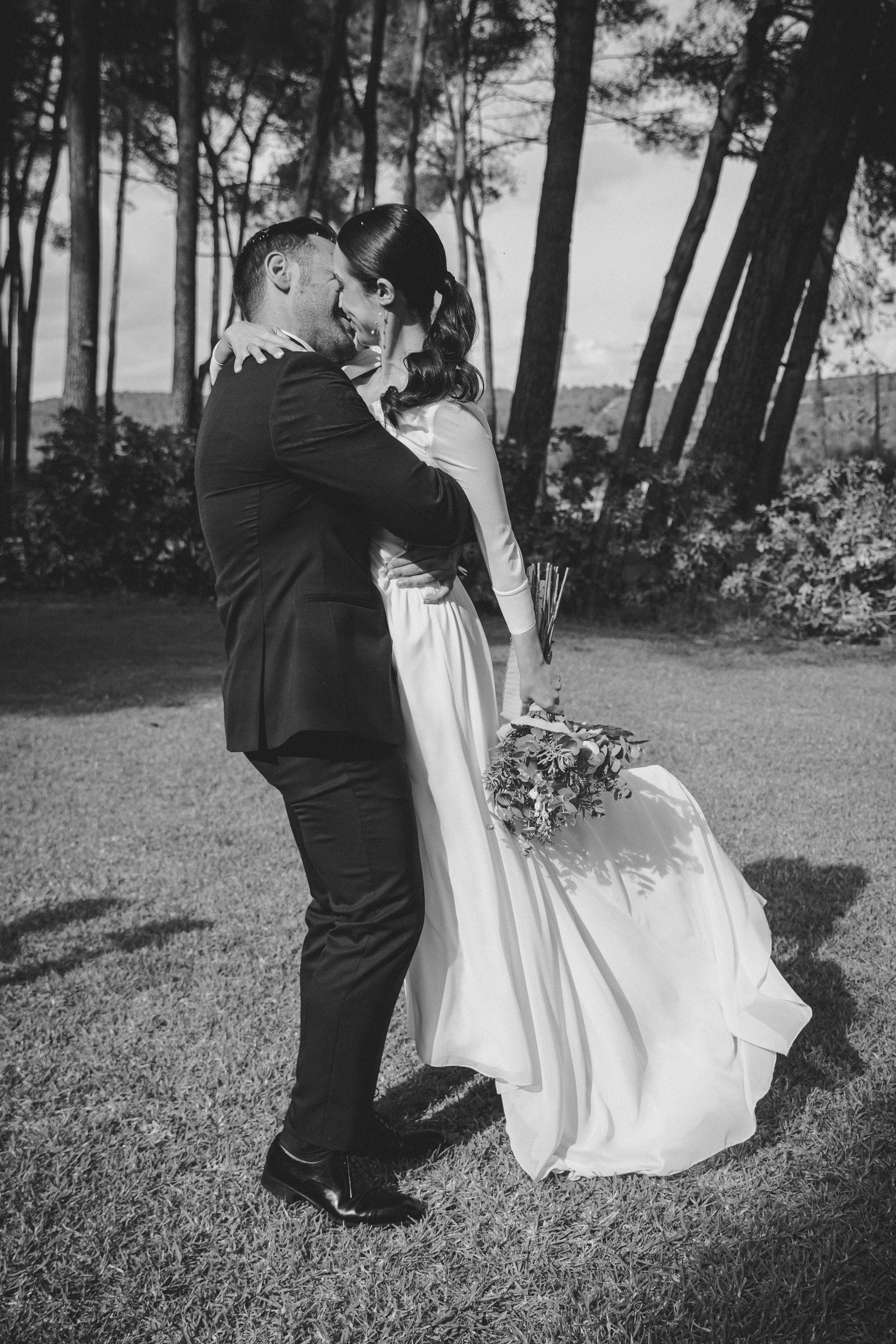 Novios abrazándose en exterior durante sesión de pareja en boda