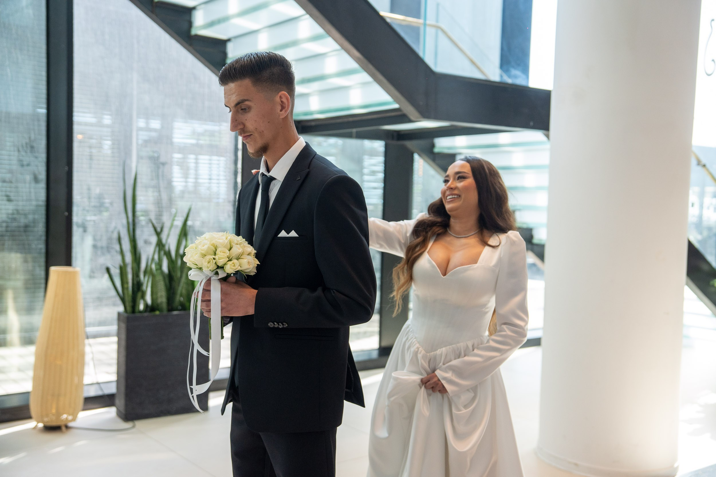 A bride approaches the groom from behind during their first look