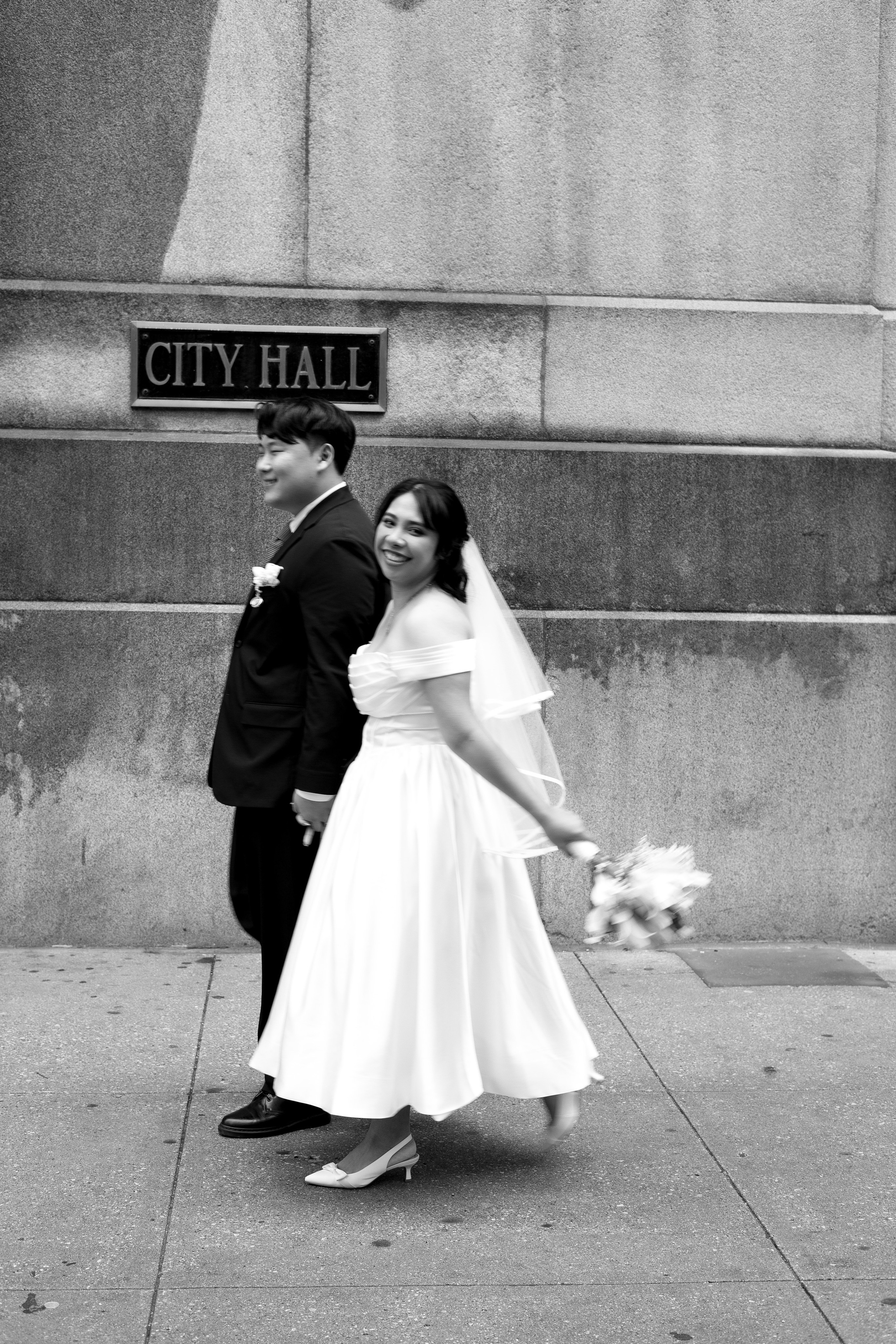 Couple walking in front of the City Hall sign after their elopement