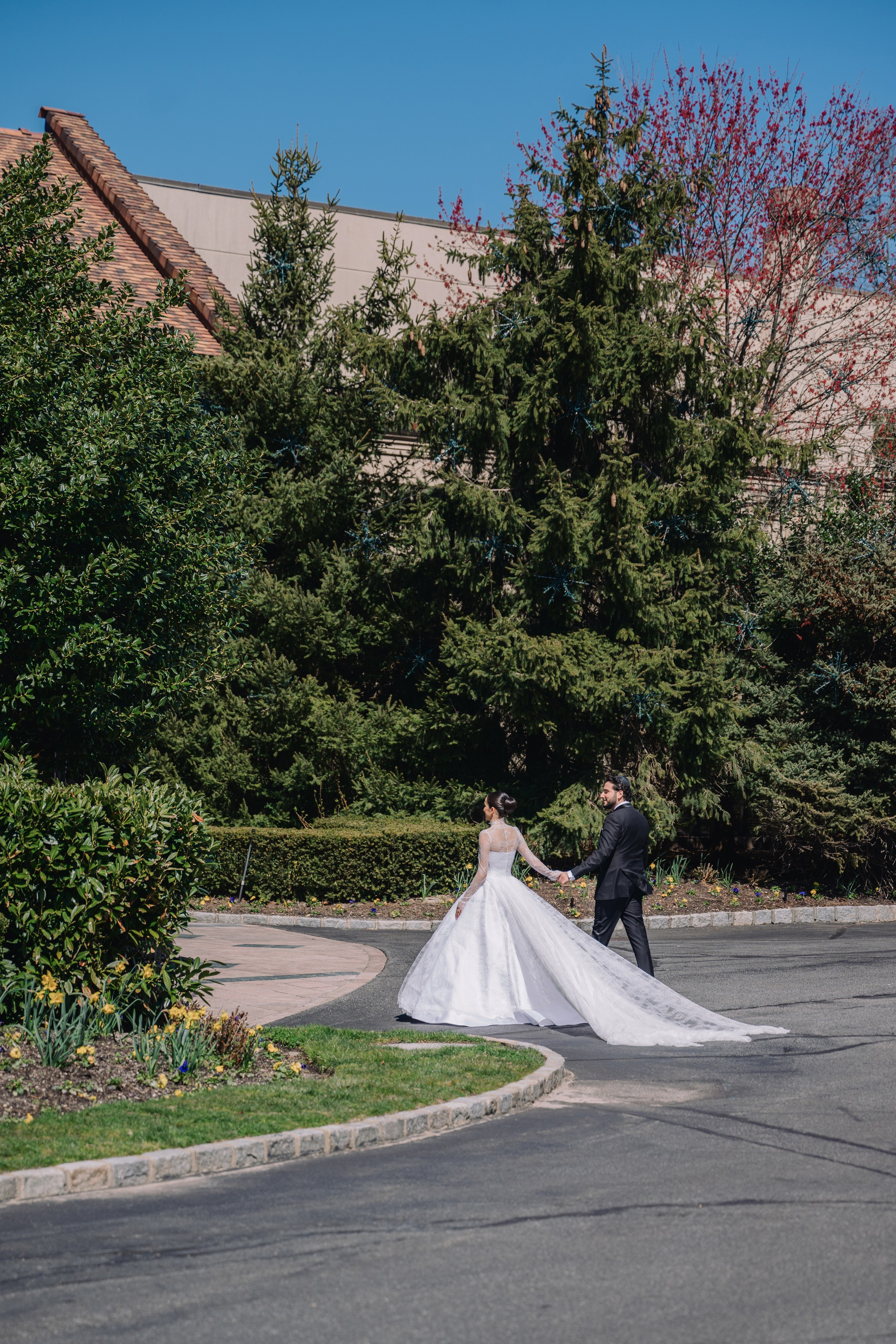 a bride and groom walking down the street