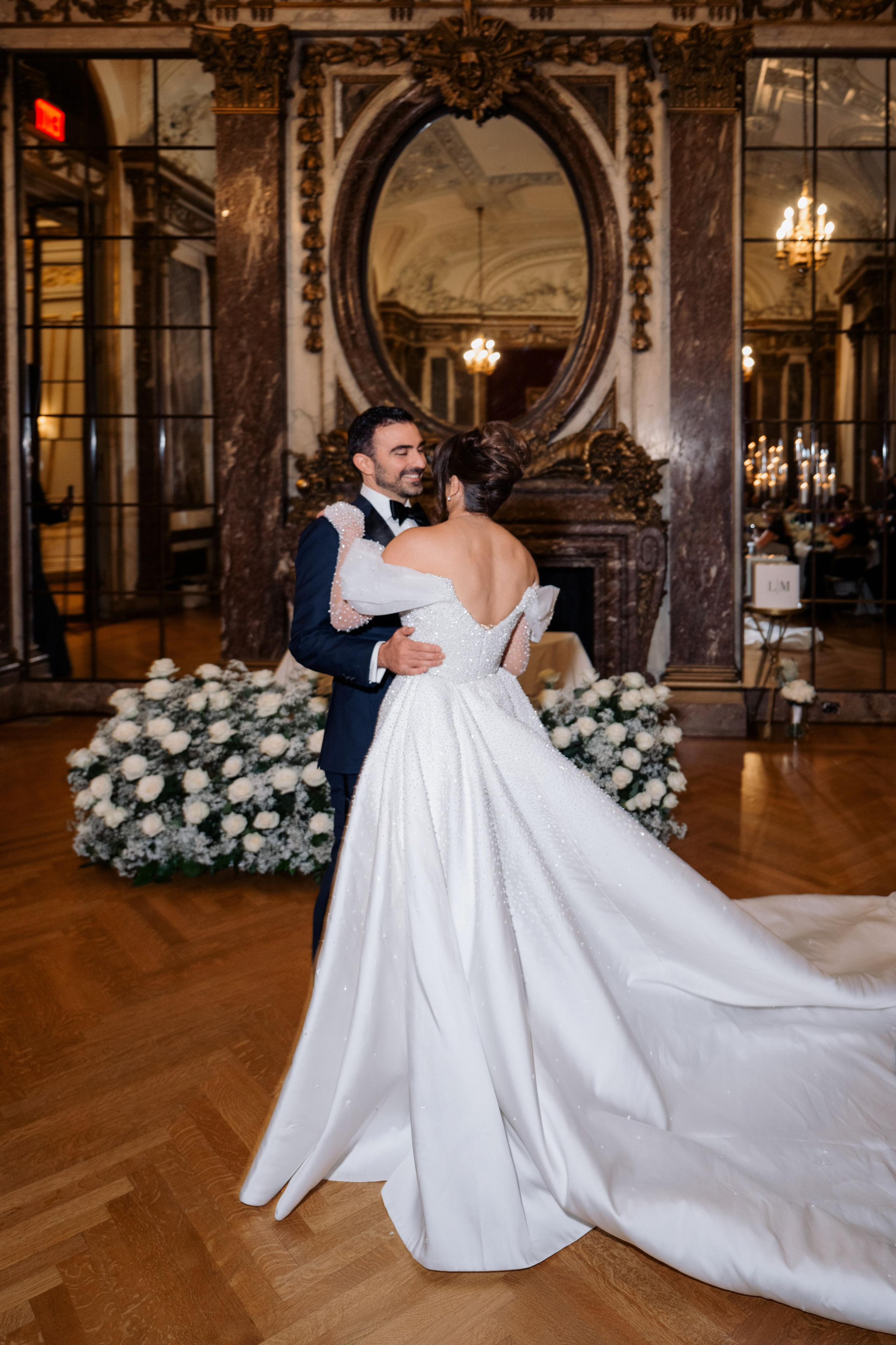 a bride and groom pose for a photo in the ballroom