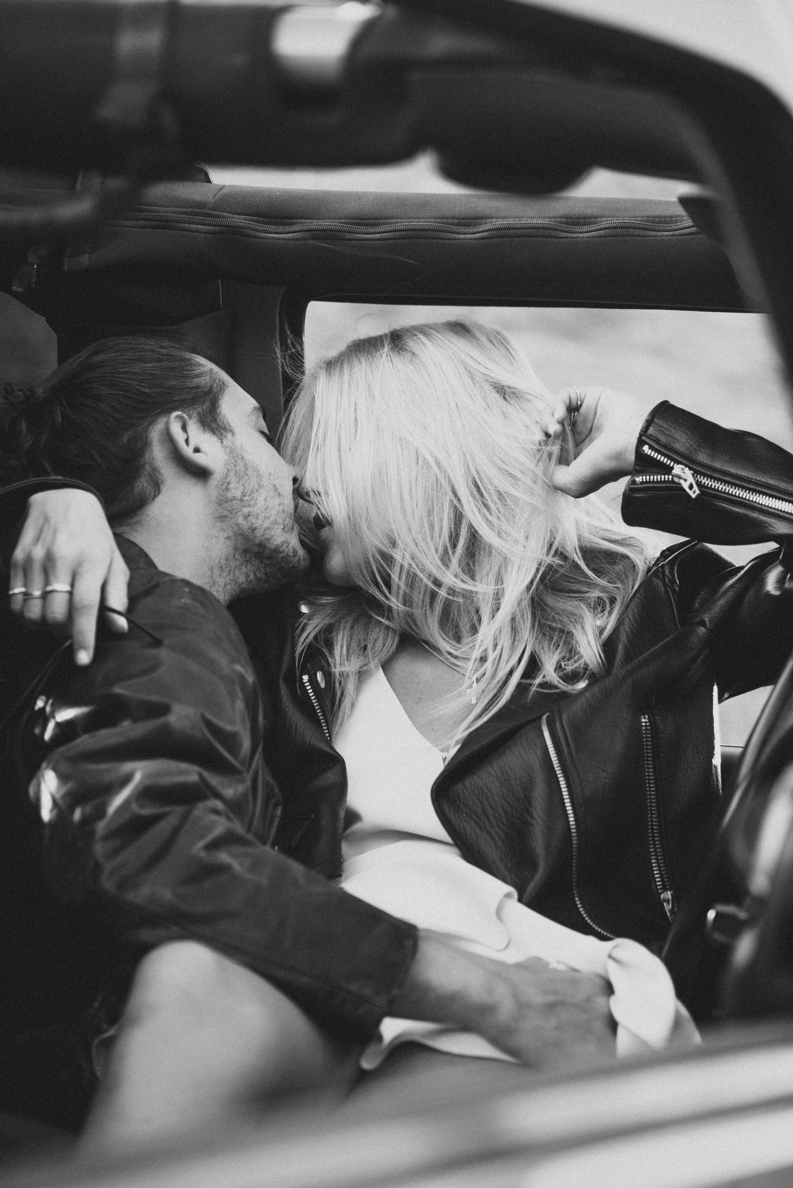 Couple's loving kiss inside the car: a heartfelt moment of affection and closeness.