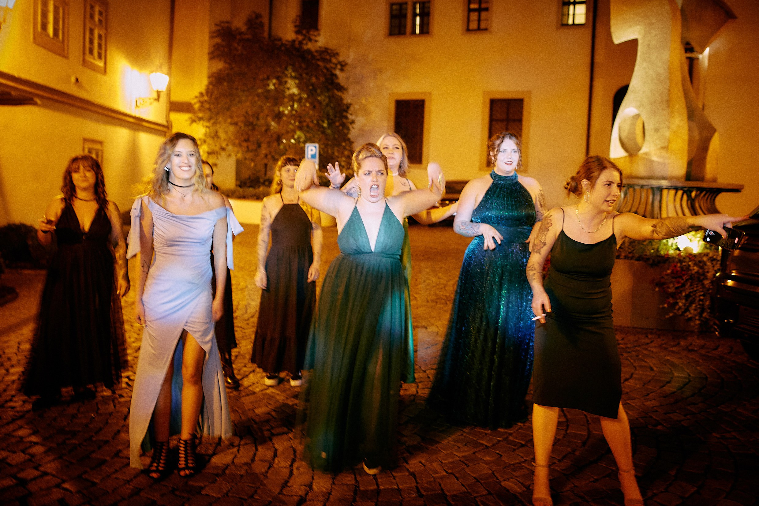 Women lined up eagerly awaiting dramatic bouquet toss.
