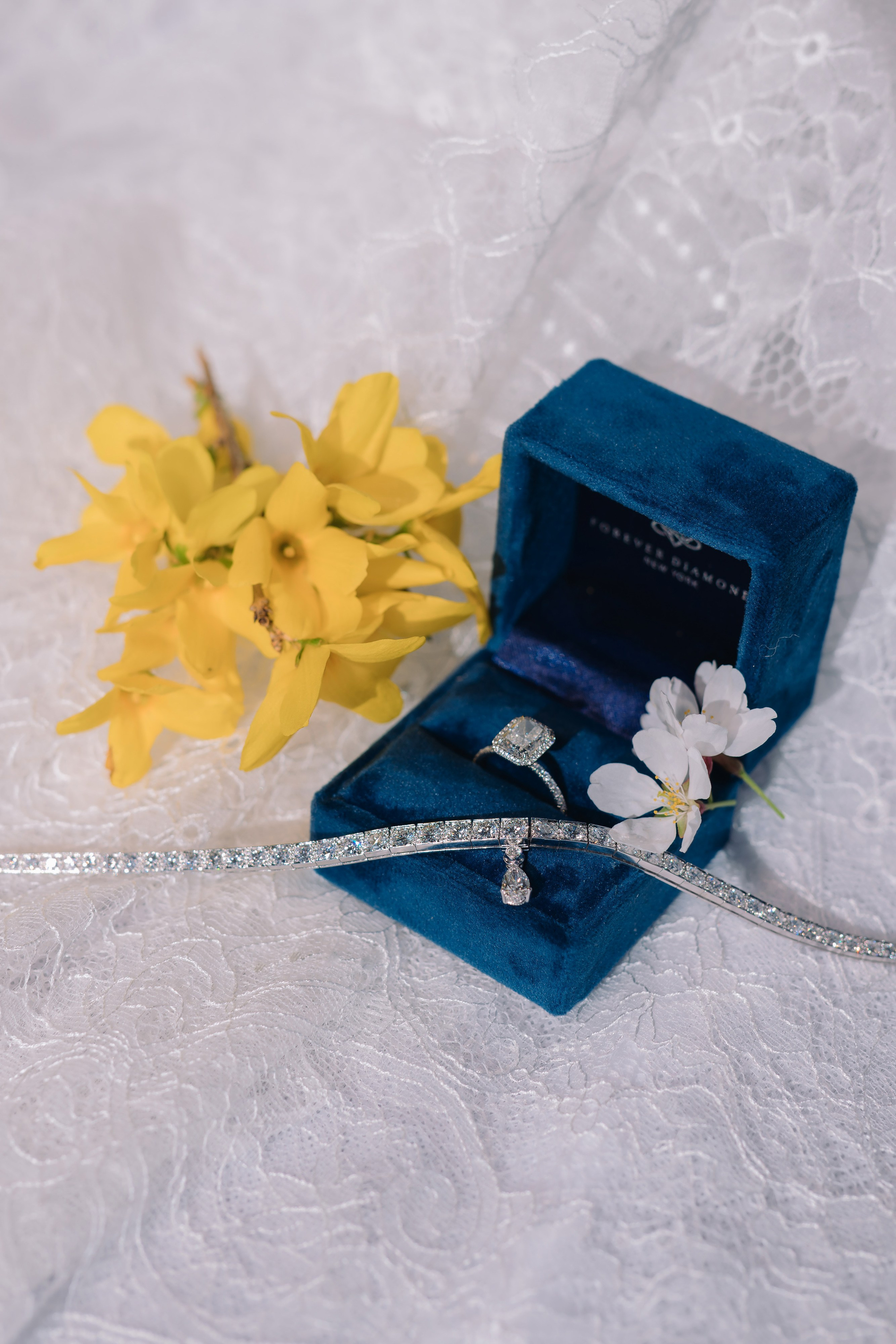 a white flower and a blue box with a ring