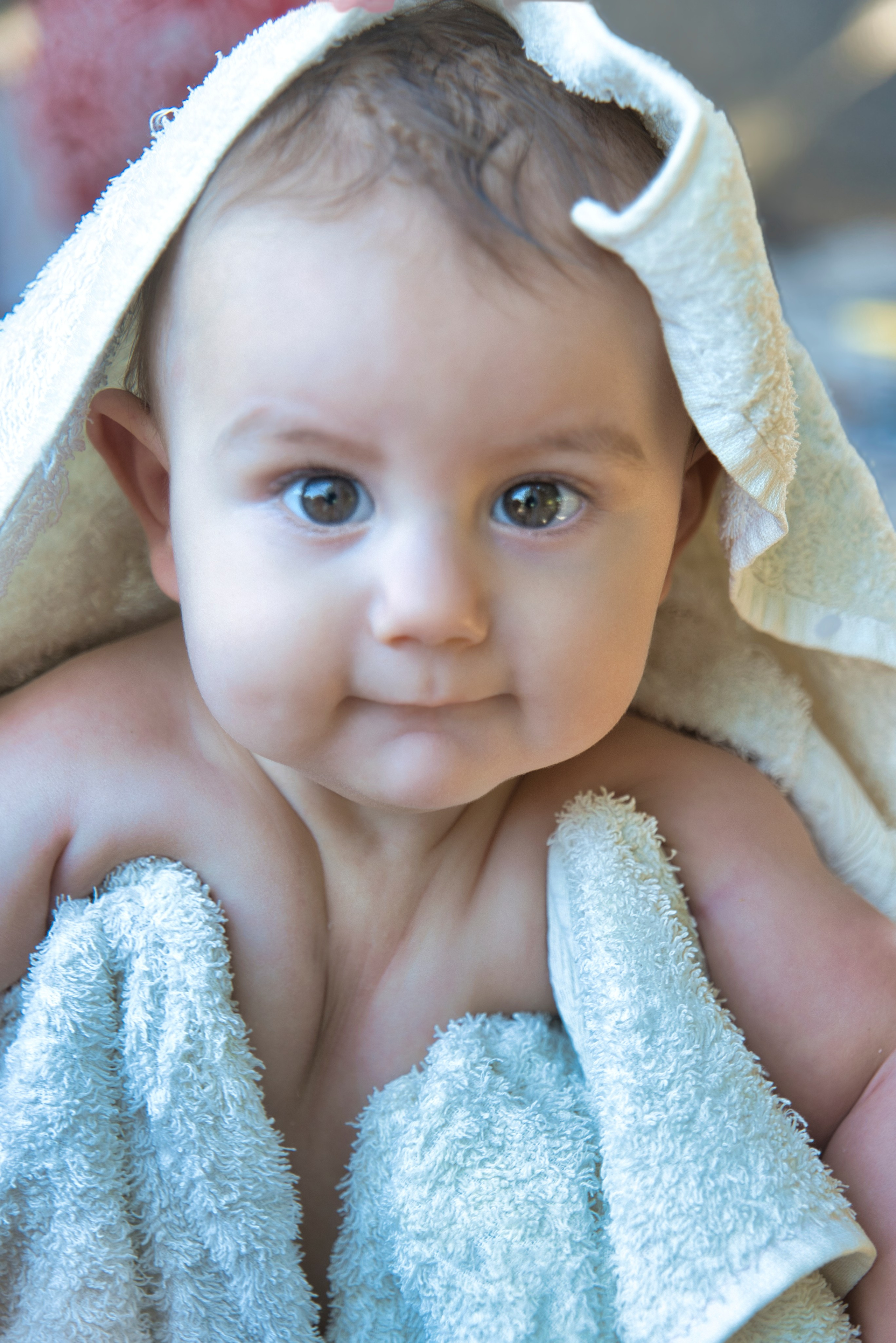 Bebé envuelto en una toalla blanca después del baño.