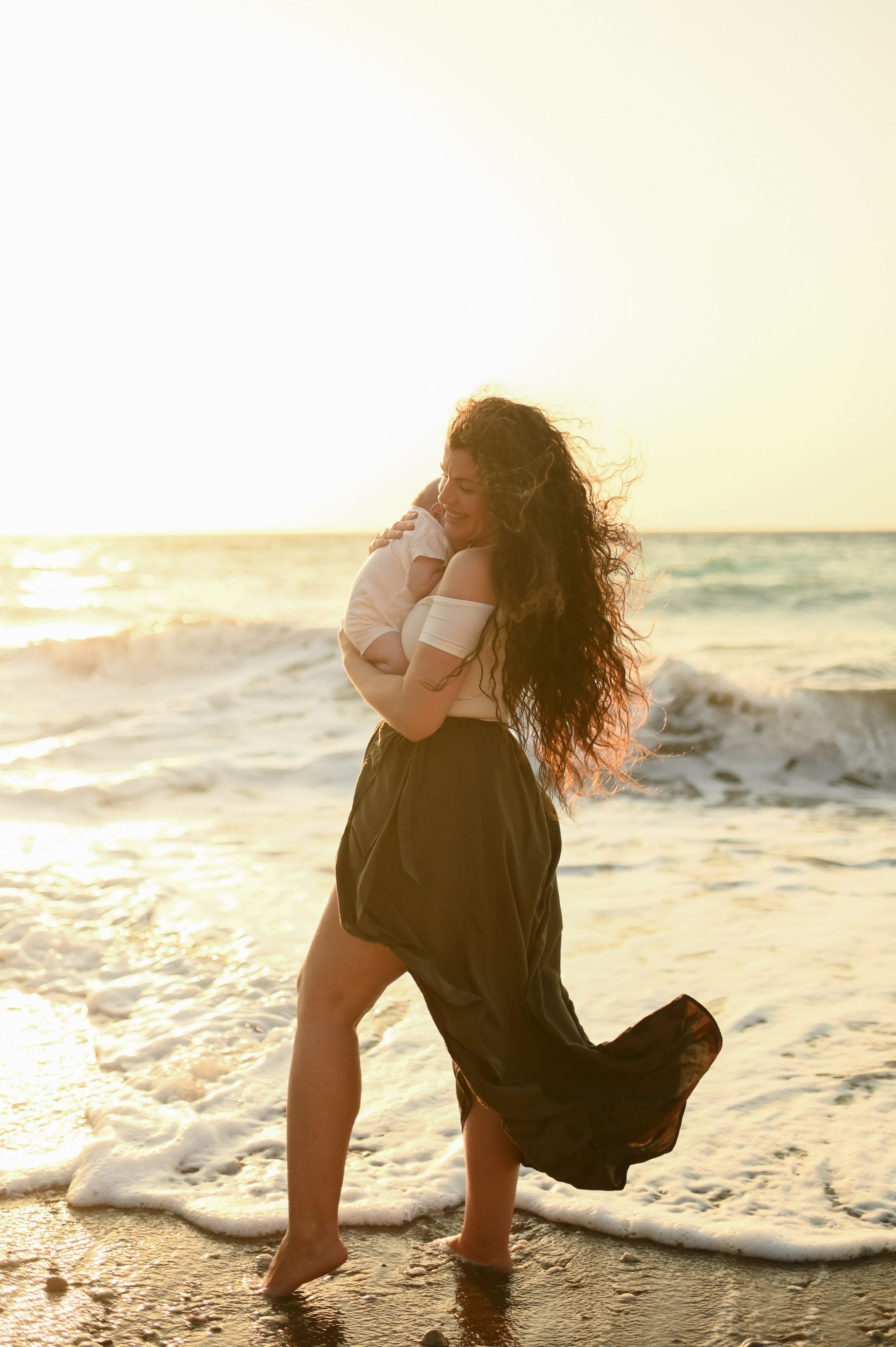 Happy family walking along a Rhodes beach at sunset. Photographer in Rhodes Island