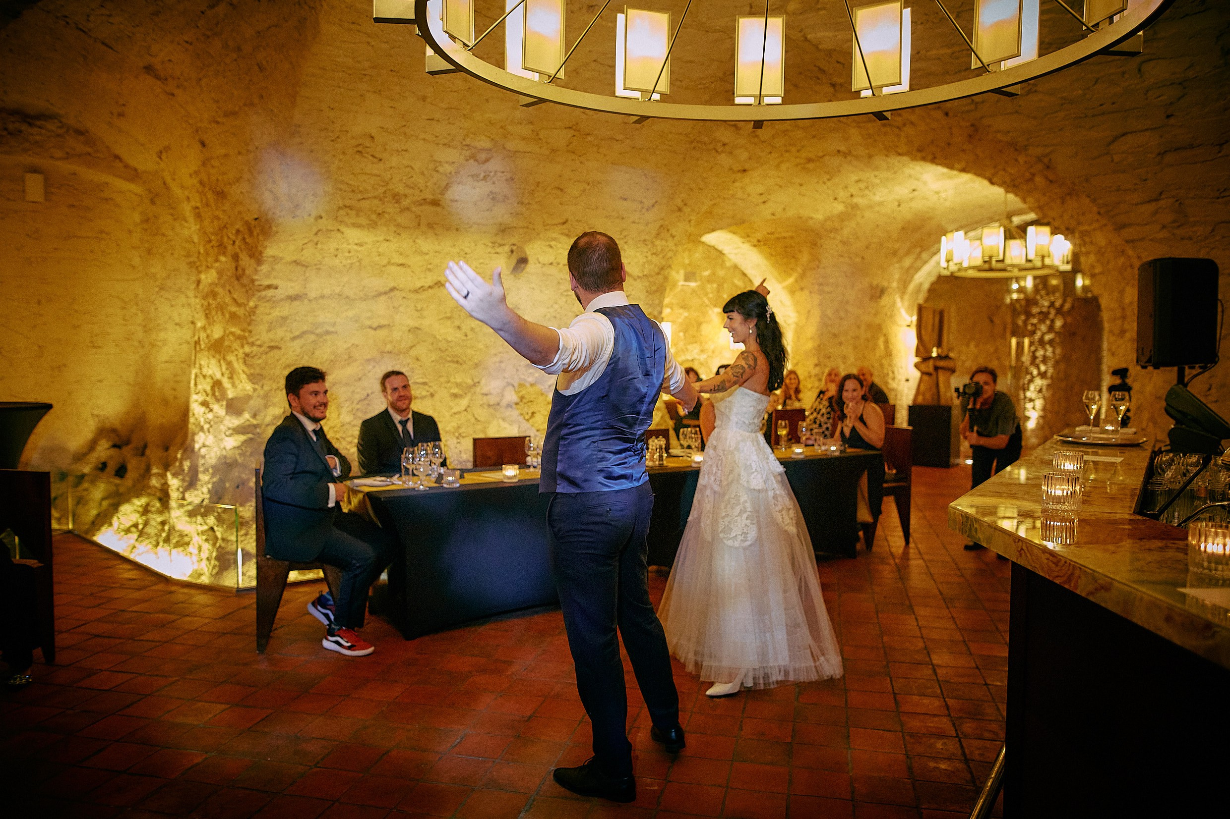 Newlyweds waving cheerfully concluding first dance at brewery venue.