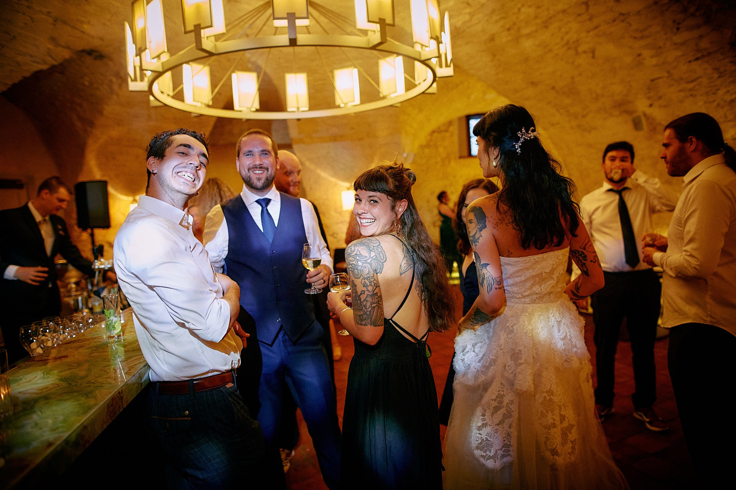 Friends embracing camaraderie at Augustine St Thomas Brewery reception.