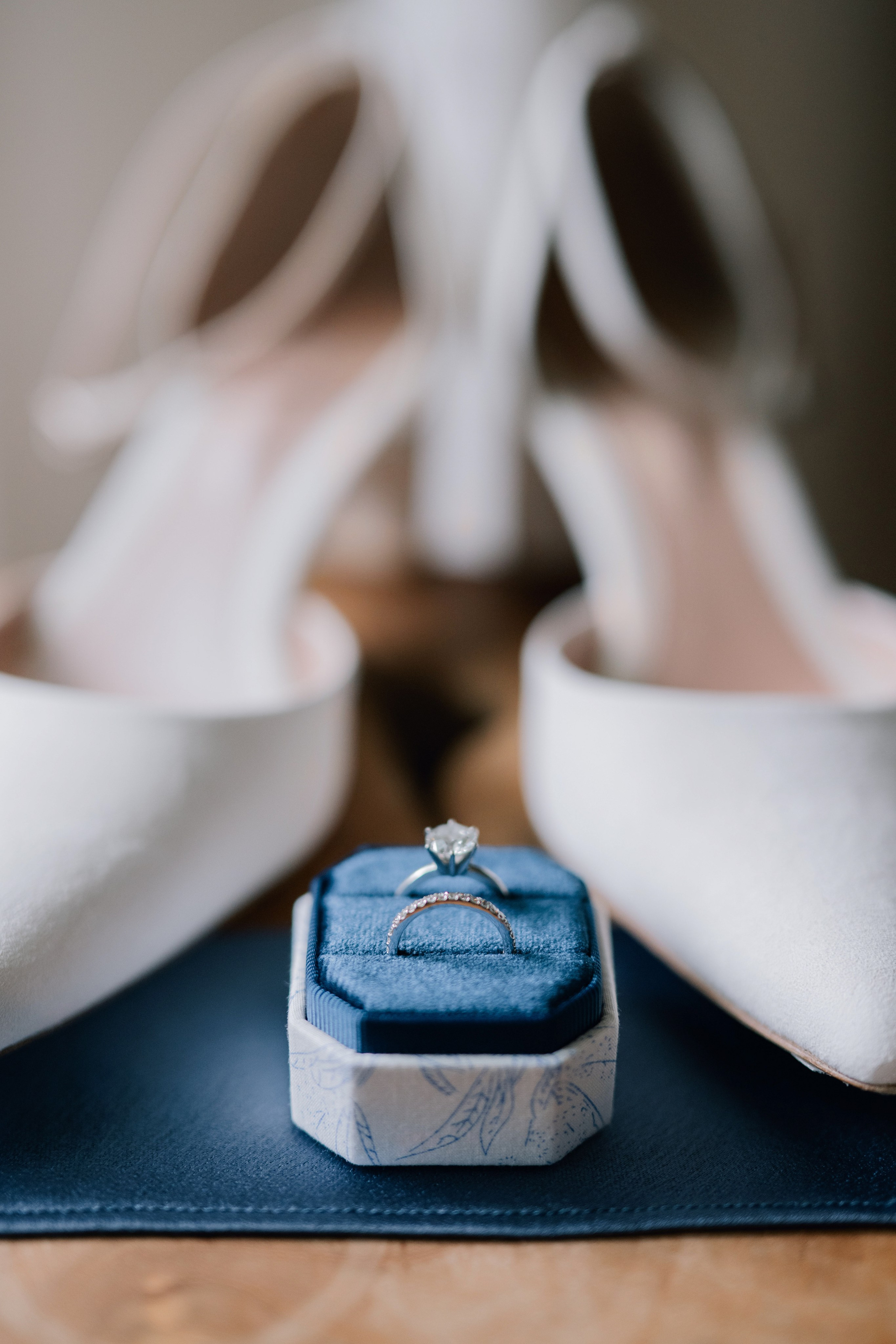 a wedding ring sits on a blue ring box