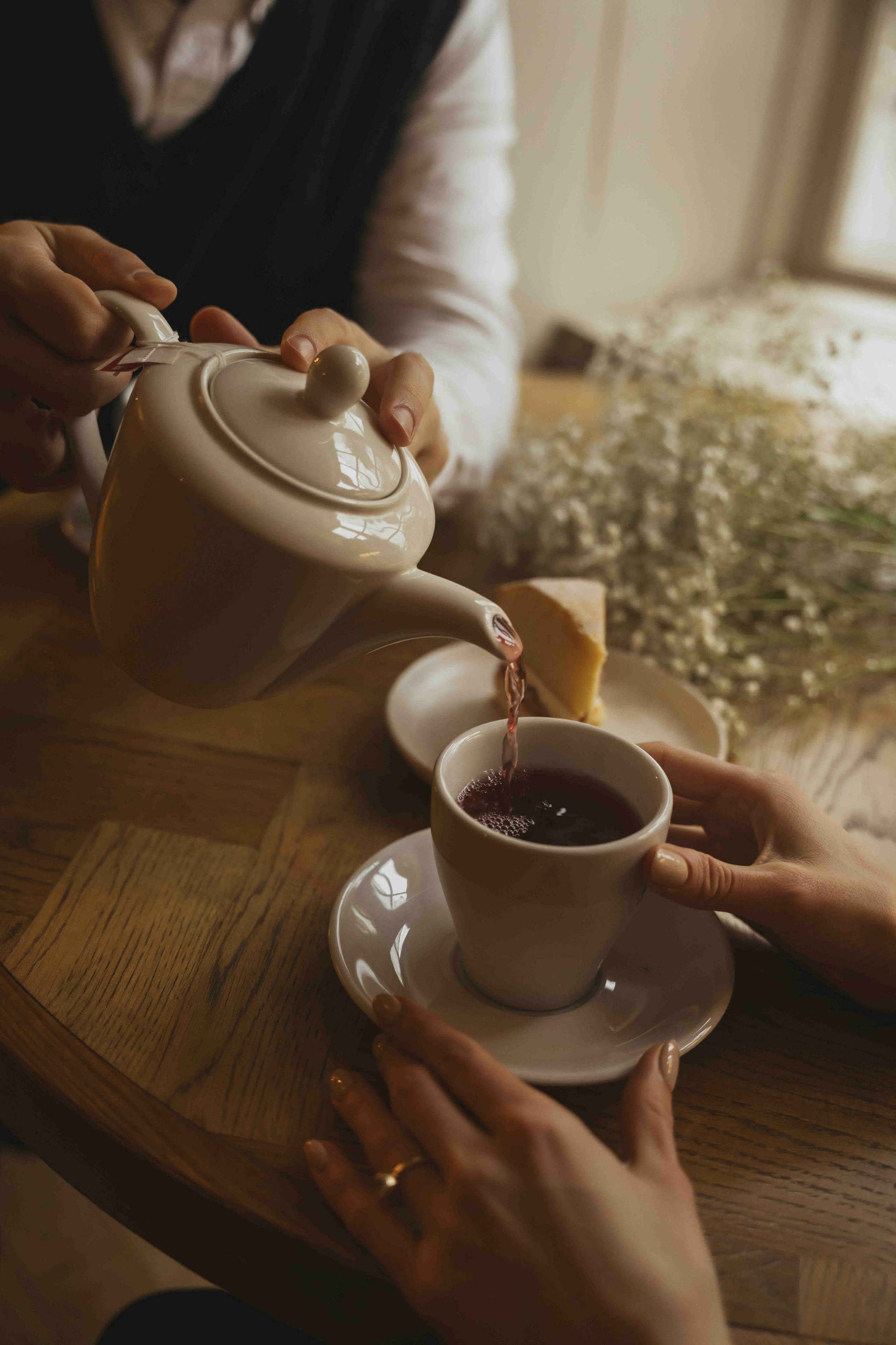 pouring tea in cozy English pub during cinematic engagement session in Castle Combe