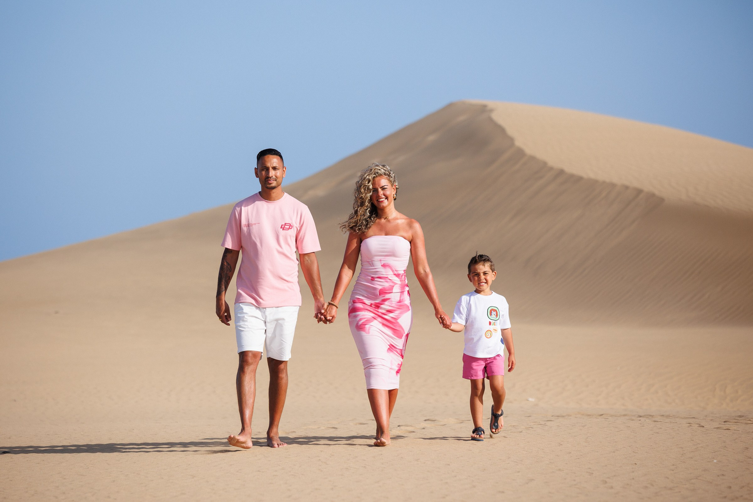 Family walking hand in hand across the Maspalomas Dunes, Gran Canaria