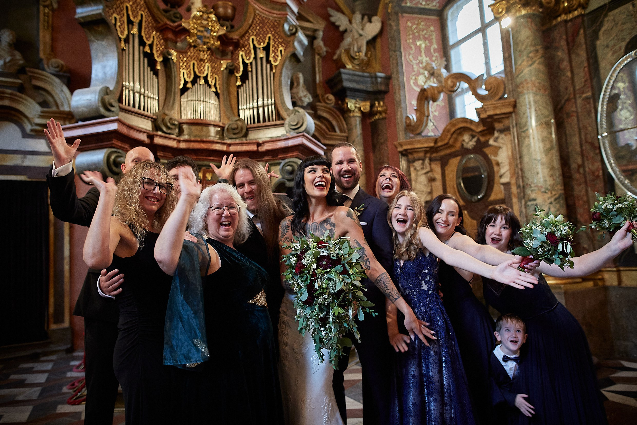 Full wedding party portrait at Klementinum Mirror Chapel altar.