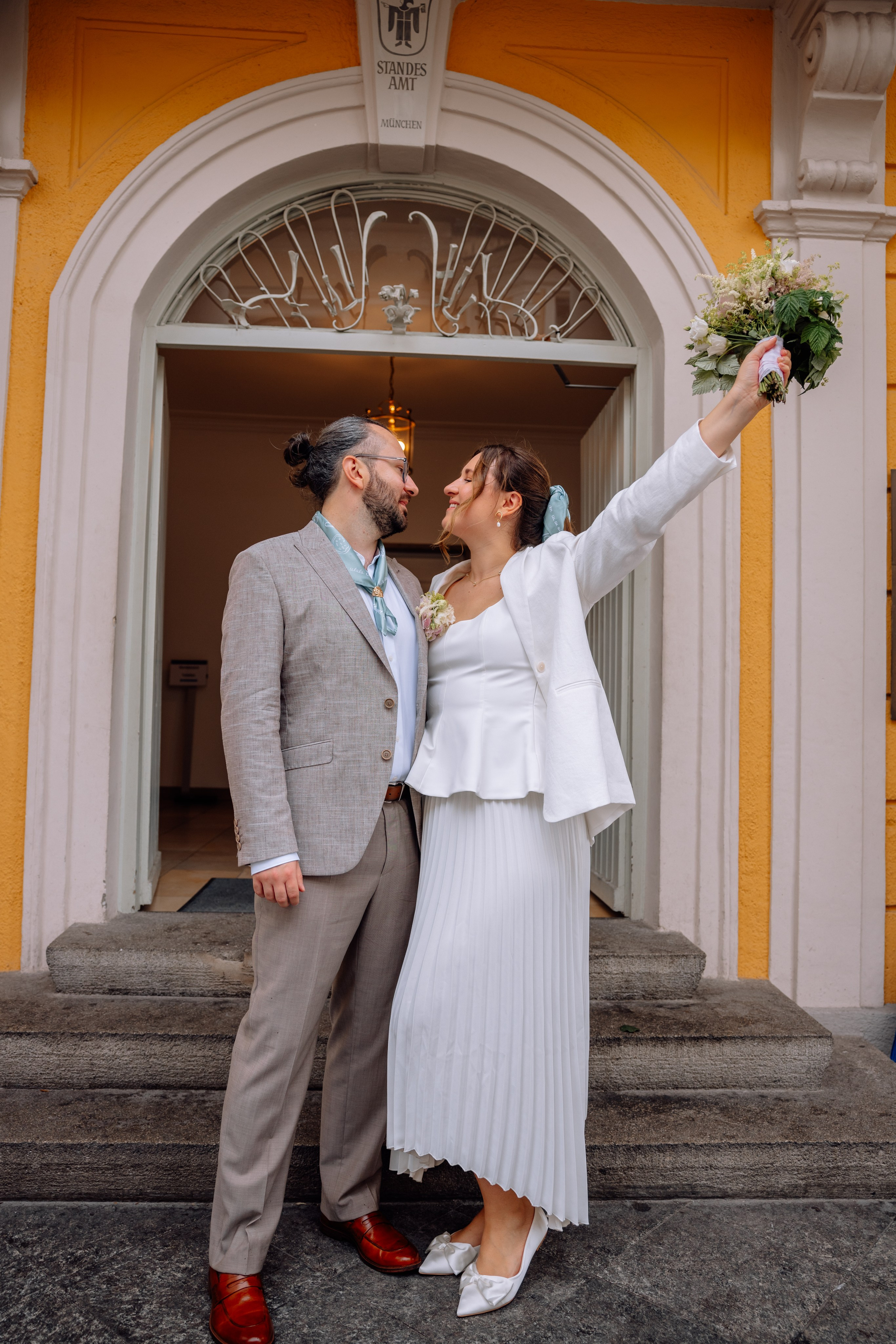 Brautpaar küsst sich beim Treppenabgang – glücklicher Moment beim Verlassen des Standesamts
