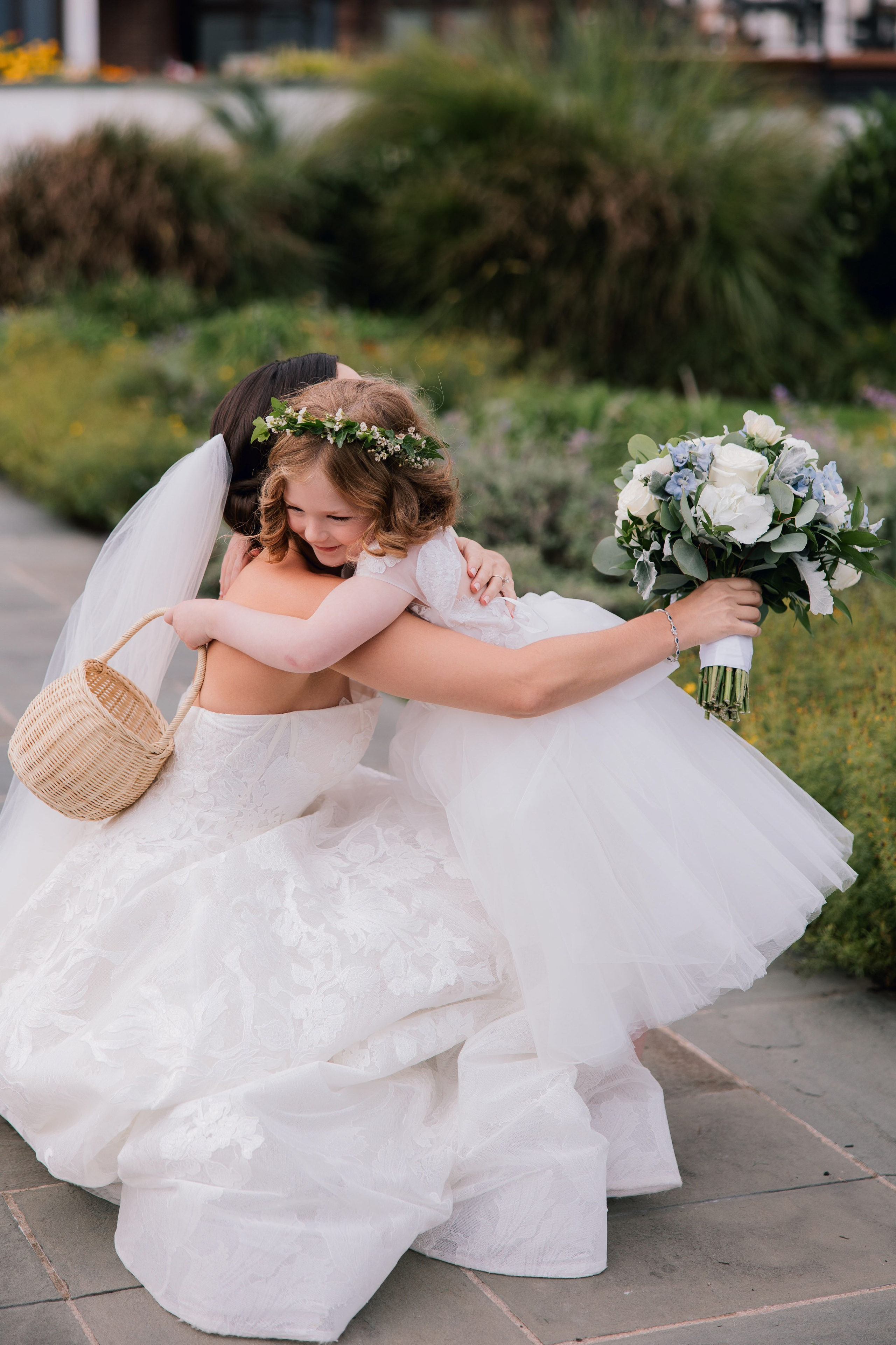 a bride is carrying her bouquet on the sidewalk