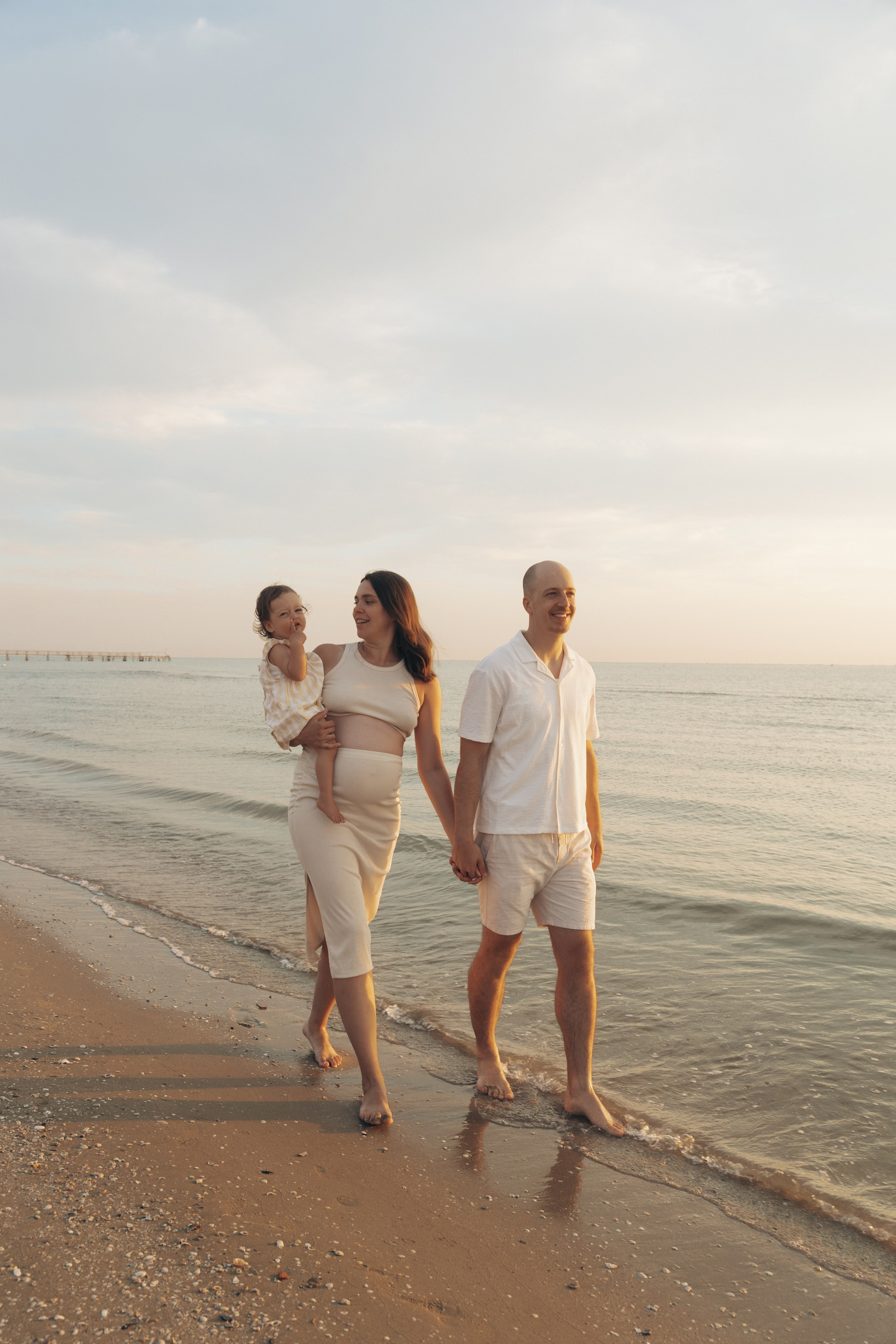 Coppia che cammina sulla spiaggia durante un servizio fotografico a Rimini.