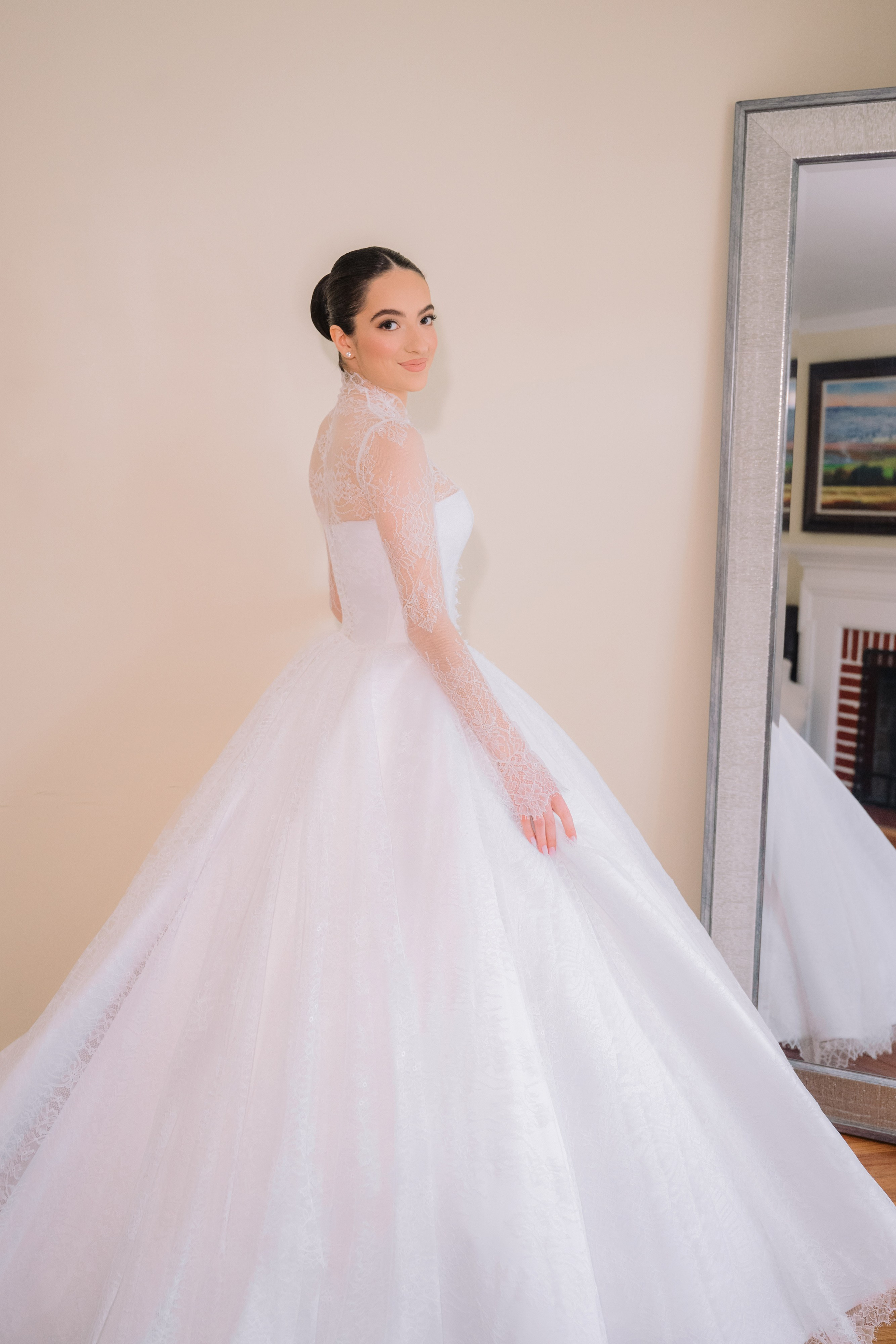 a woman in a white wedding dress standing in front of a mirror