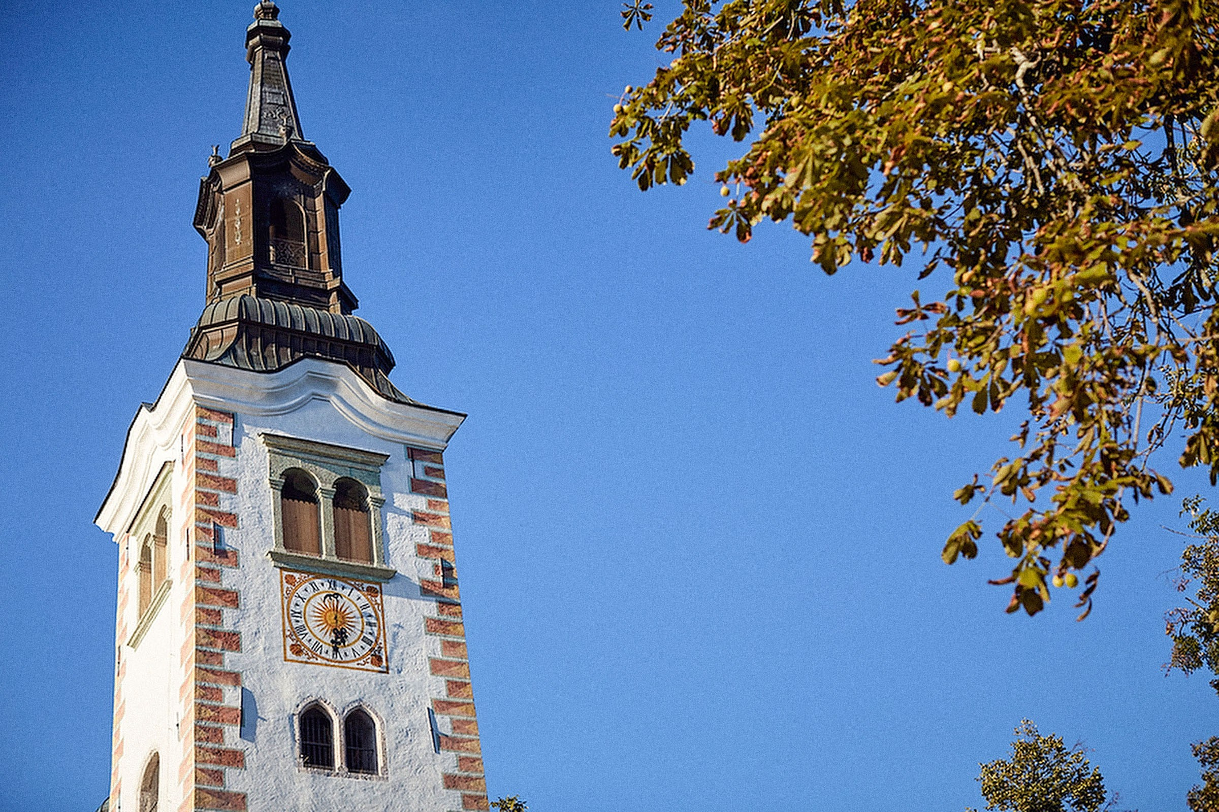 A church bell tower is seen against the deep blue sky.