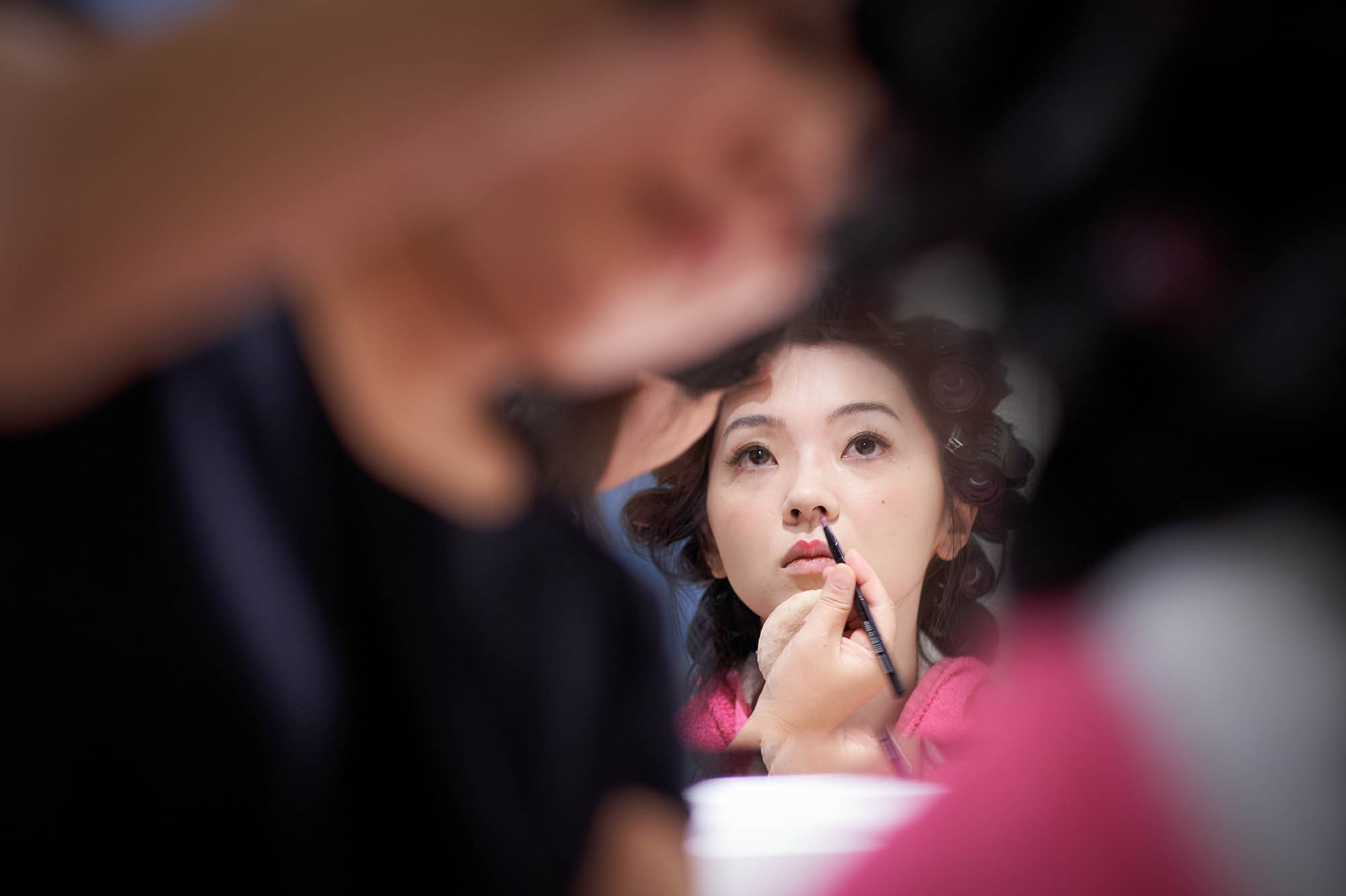 Bride Hitomi having makeup applied by Parisian artist in Palais Coburg suite.