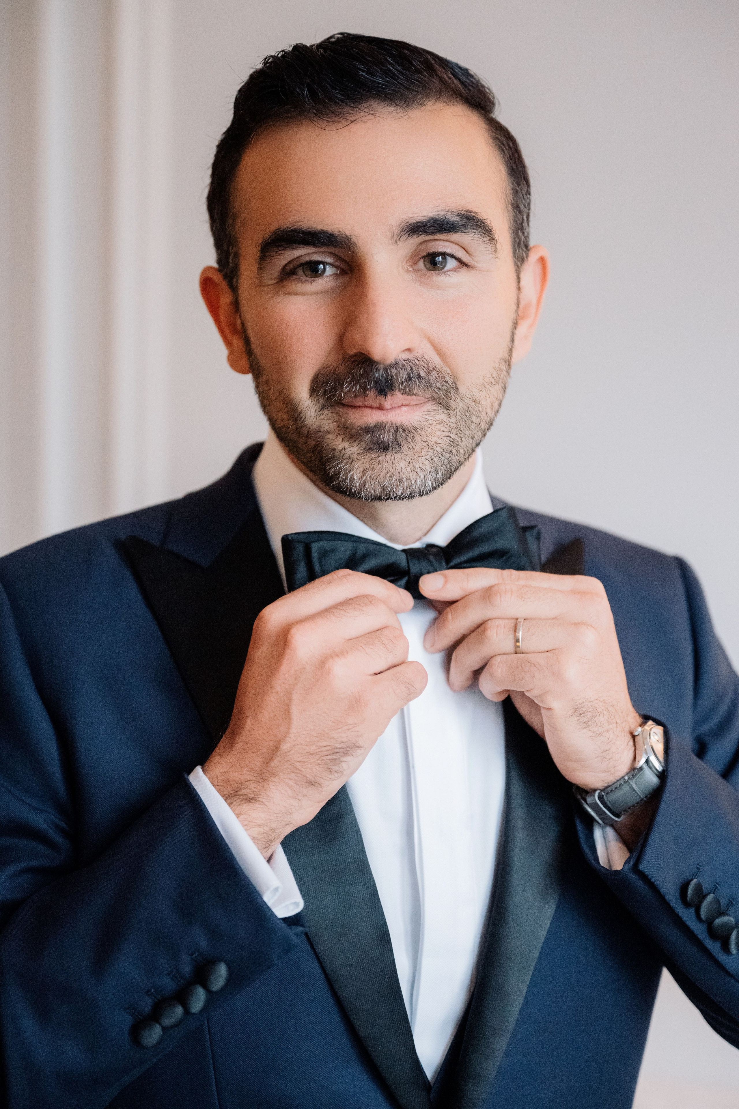 a man in a suit adjusting his tie