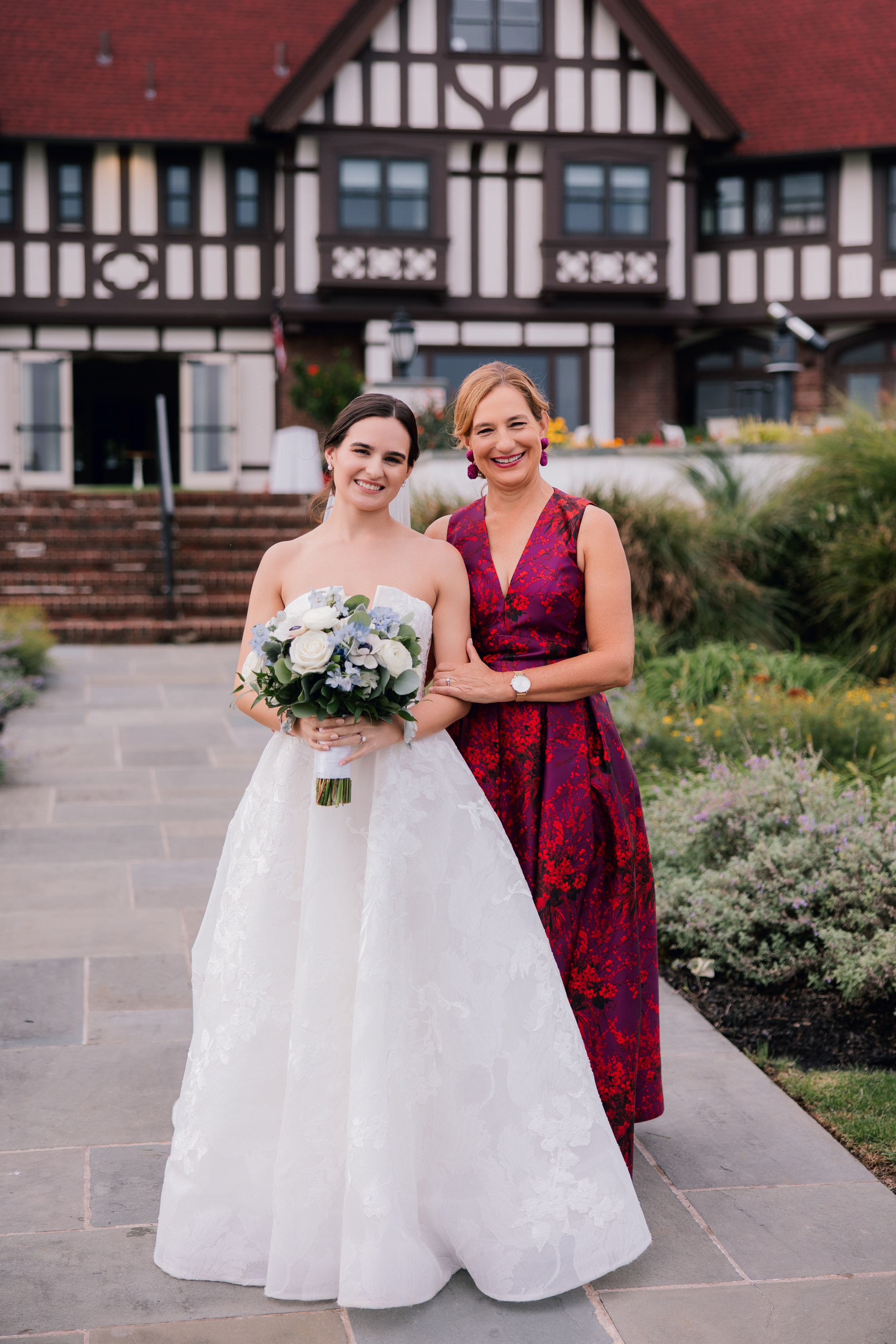 a bride and her mother pose for a photo