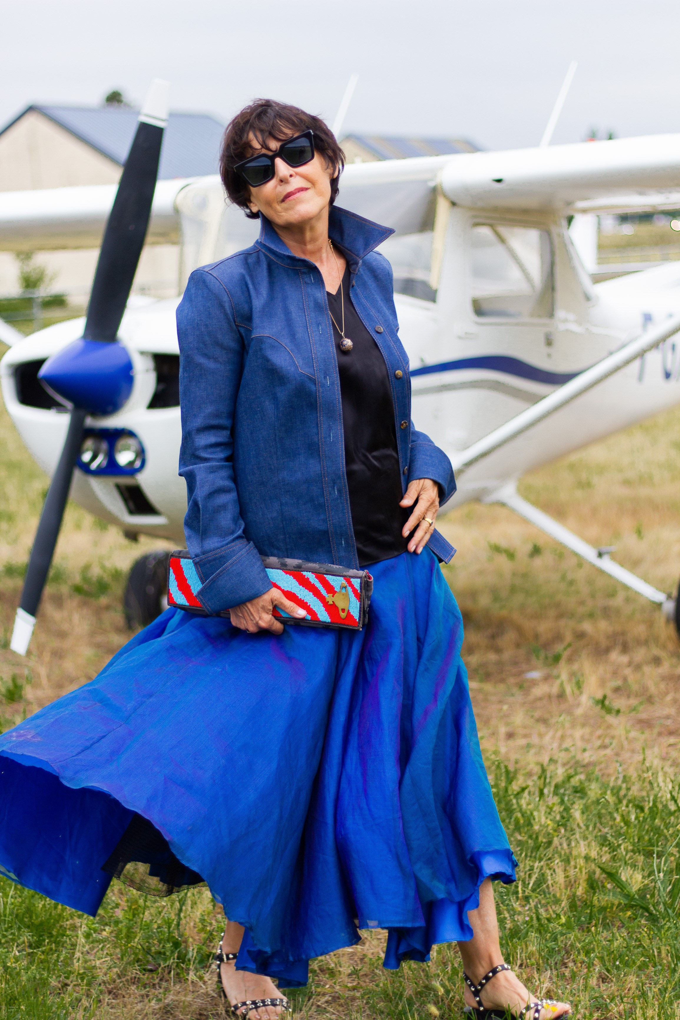 Une styliste de Bordeaux, vêtue d'une tenue bleue, pose pour un photographe professionnel lors d'un shooting à l'aéroport
