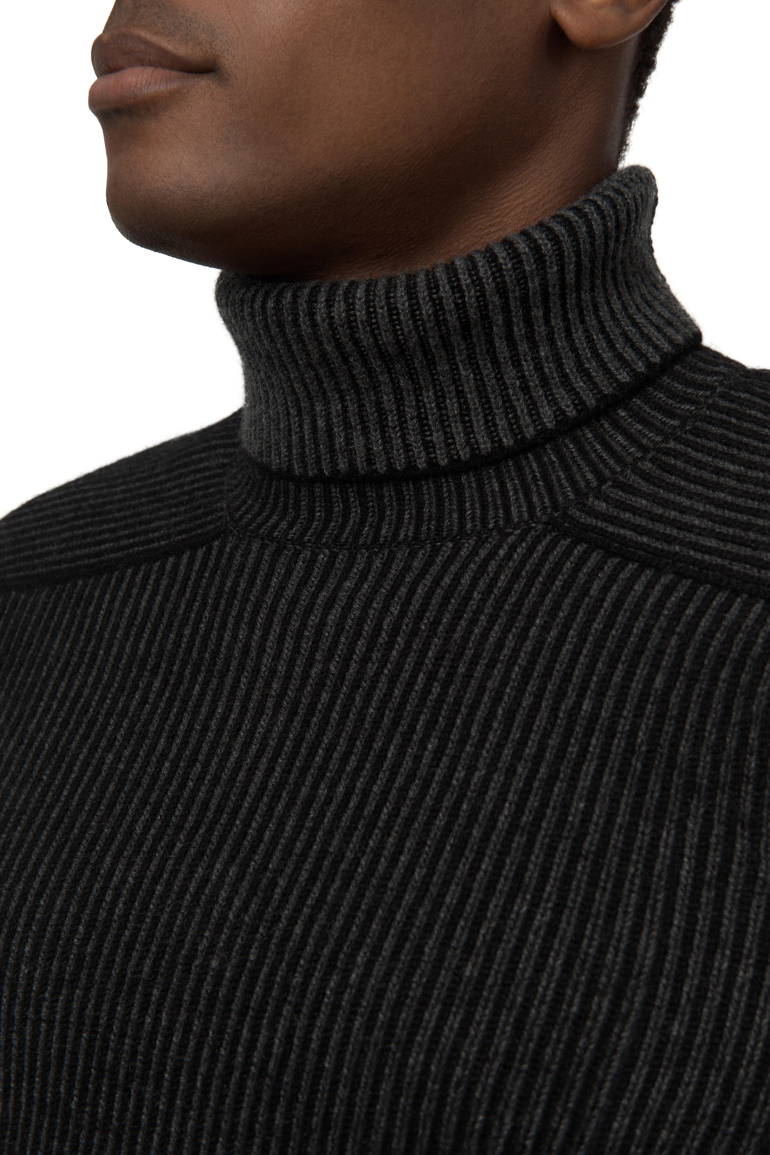 Nahaufnahme – Hals- und Kragenbereich eines schwarzen Rollkragenpullovers.