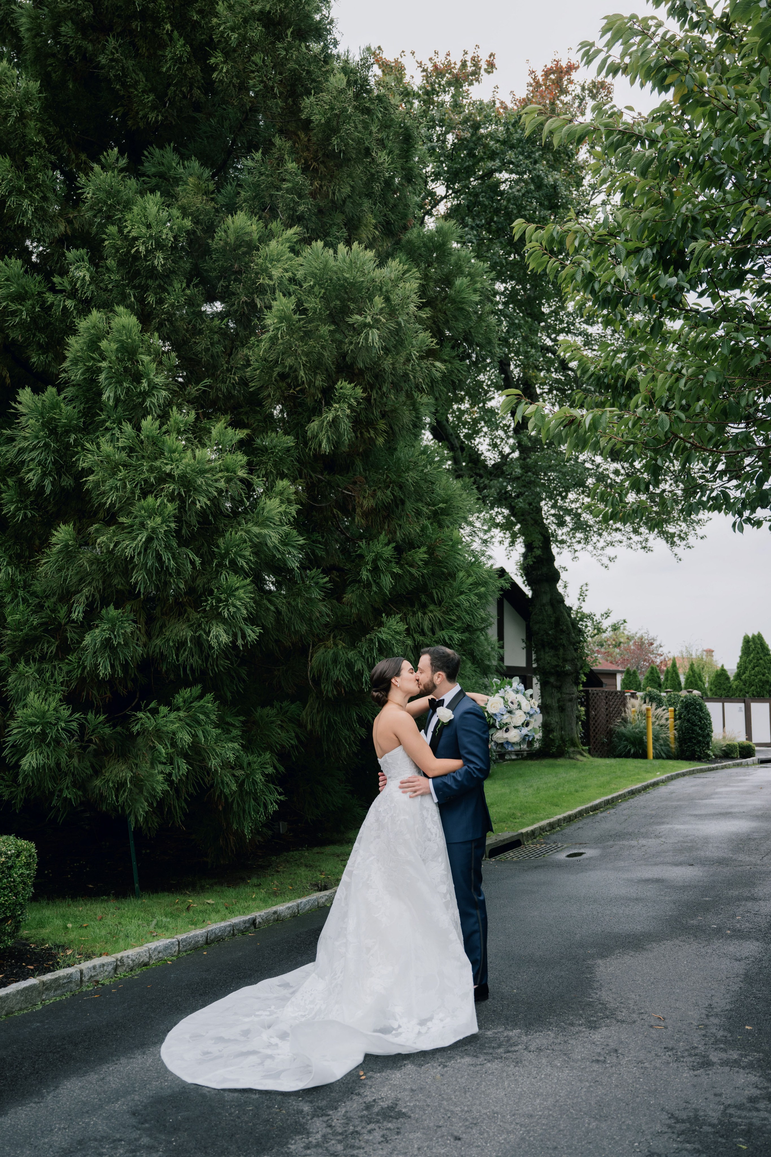 a bride and groom kissing in the street