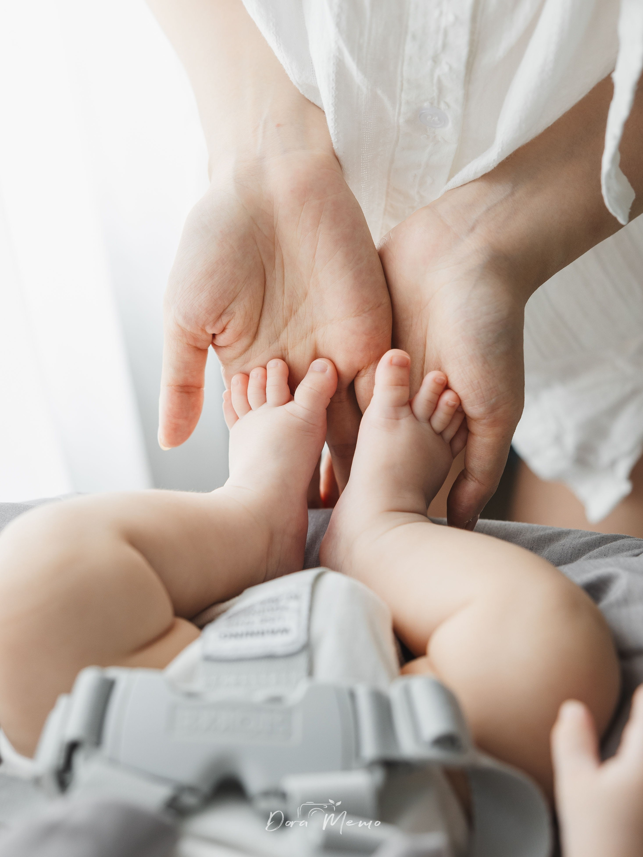 Tiny baby feet held gently in parents' hands, photographed as part of a natural family story.
