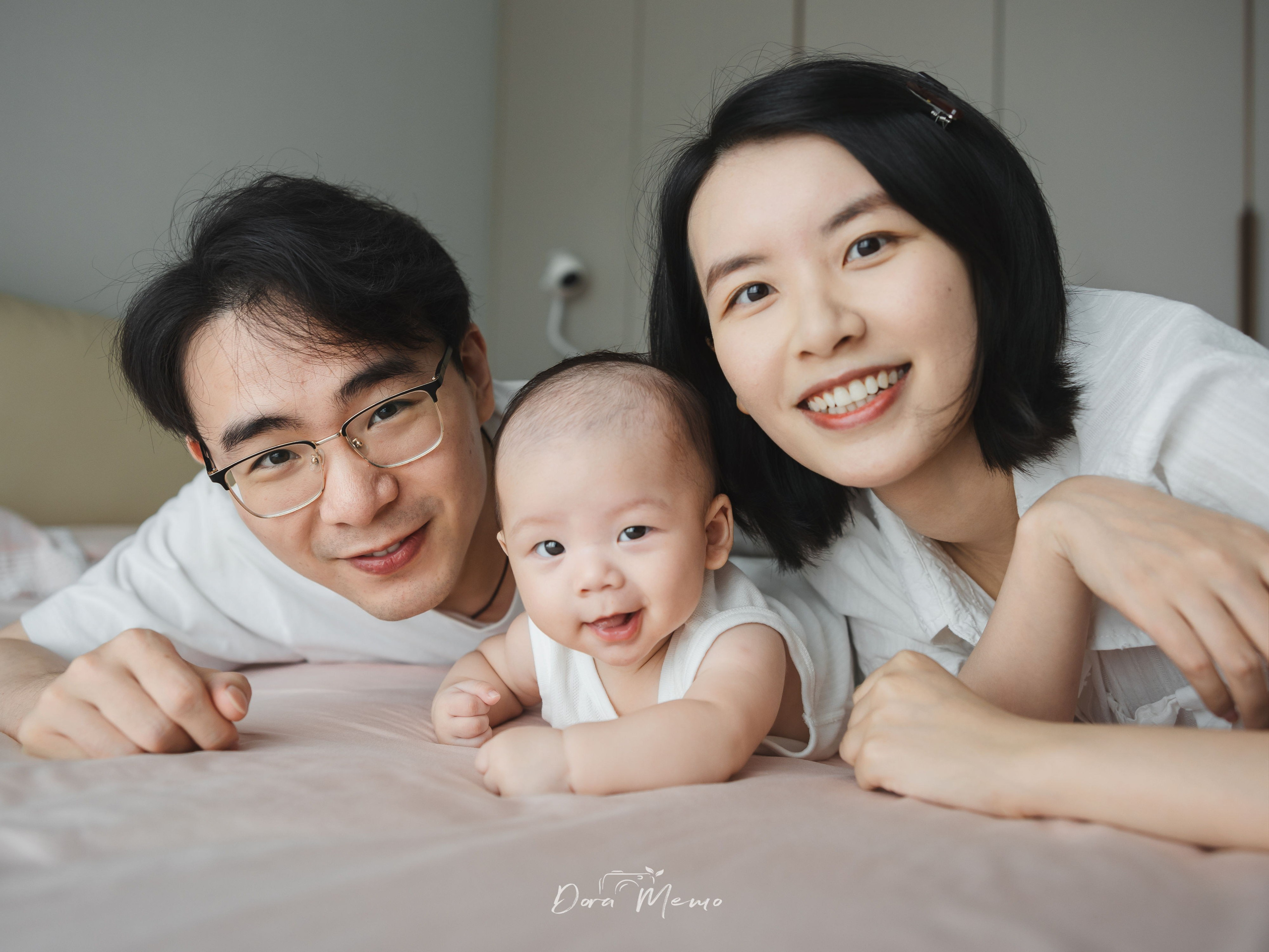 Parents and baby sharing a relaxed bed moment during a lifestyle family photo session.