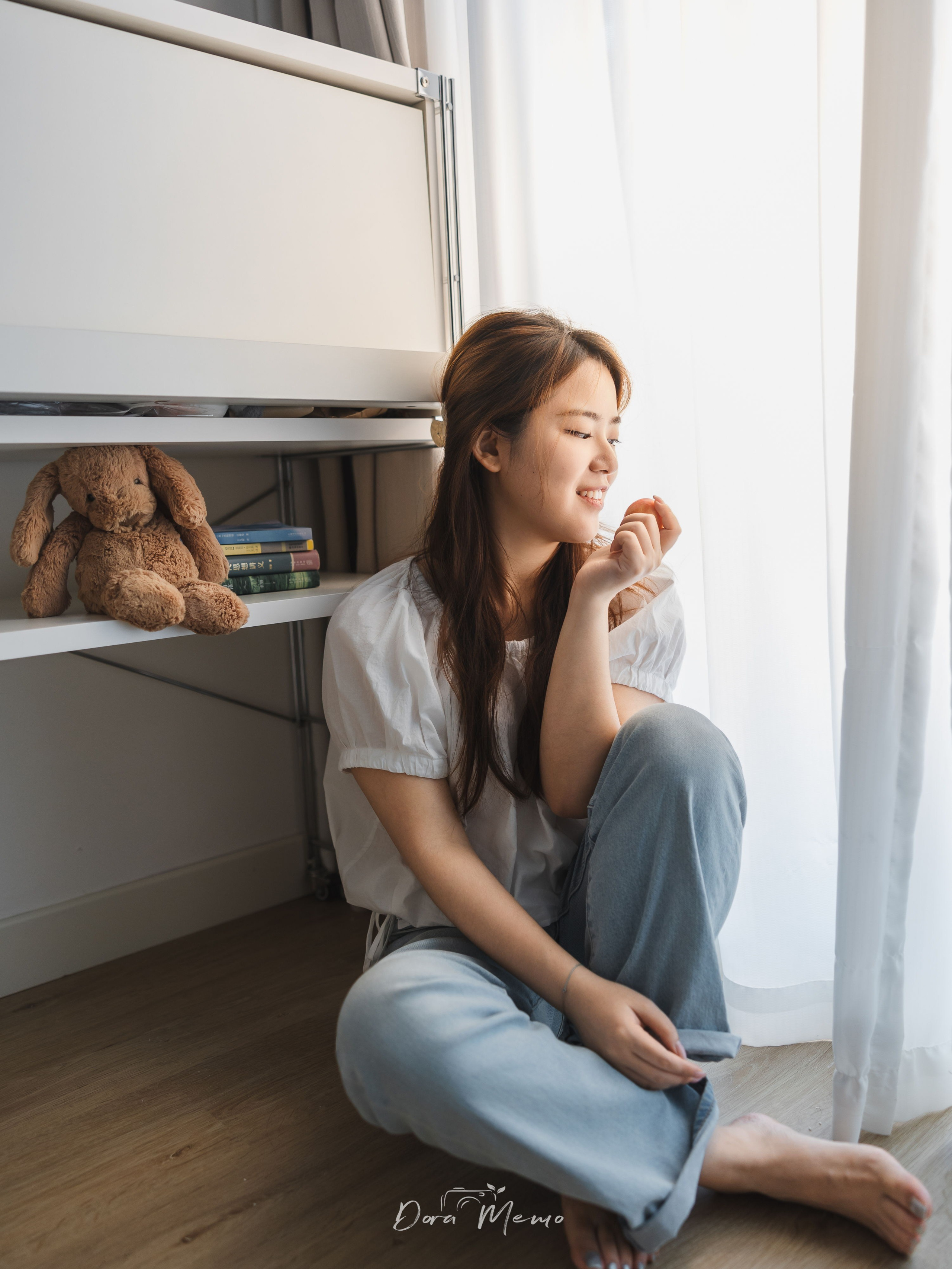 A quiet portrait of a woman sitting by the window during a documentary family photography session in Shanghai.