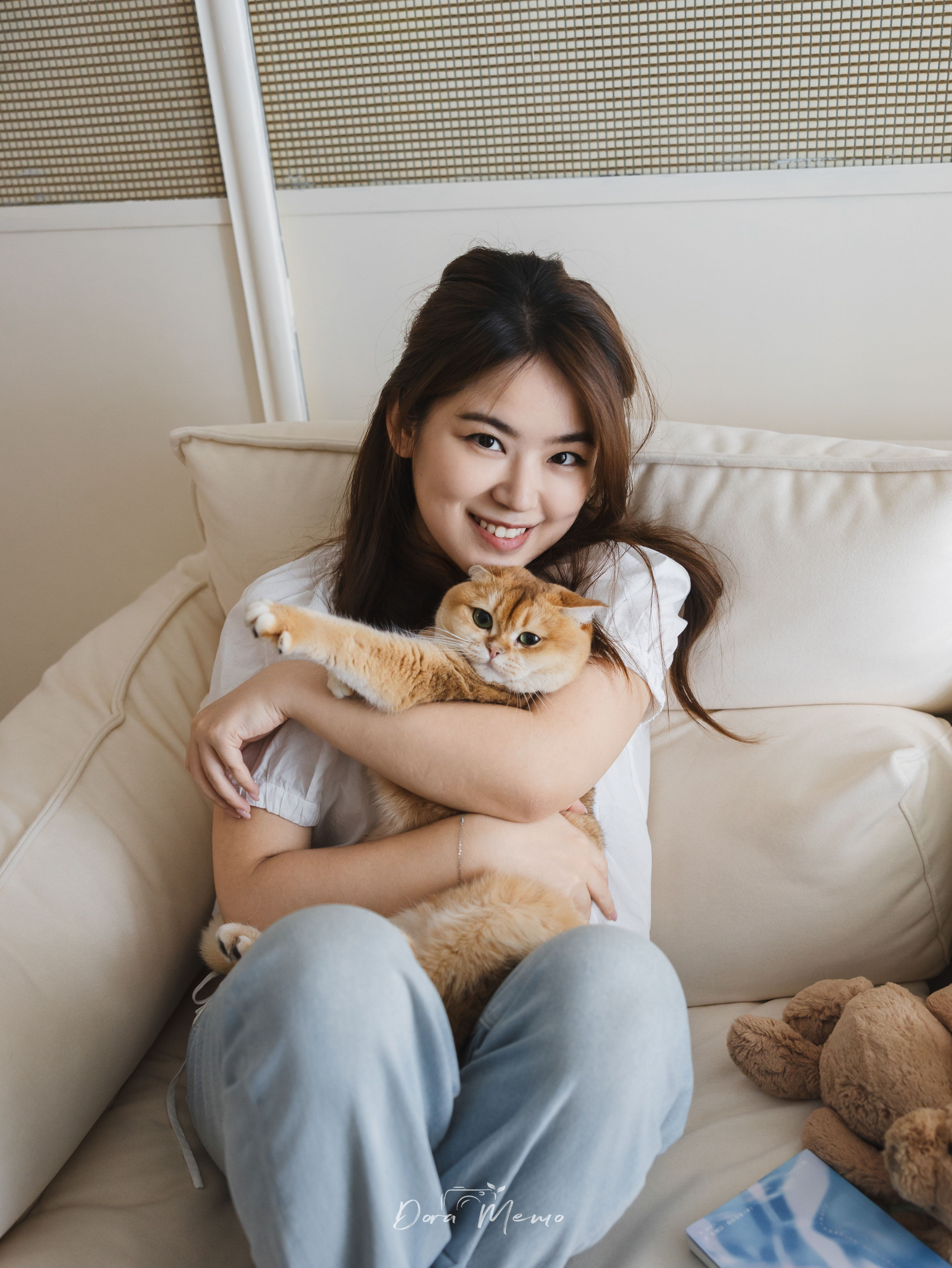 A woman cuddles her golden shaded cat at home during a natural Shanghai family photography session.