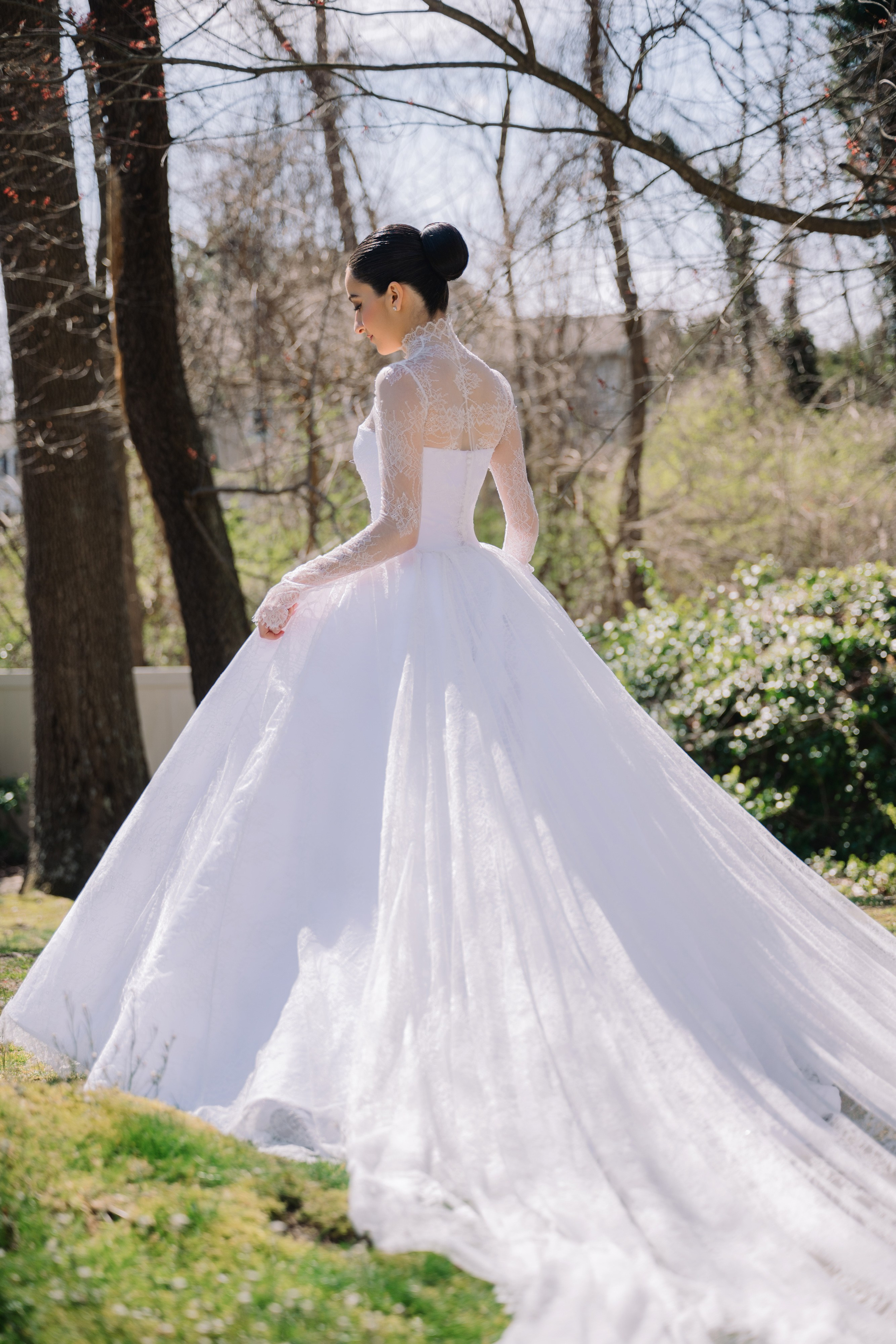 a woman in a white wedding dress standing in the grass