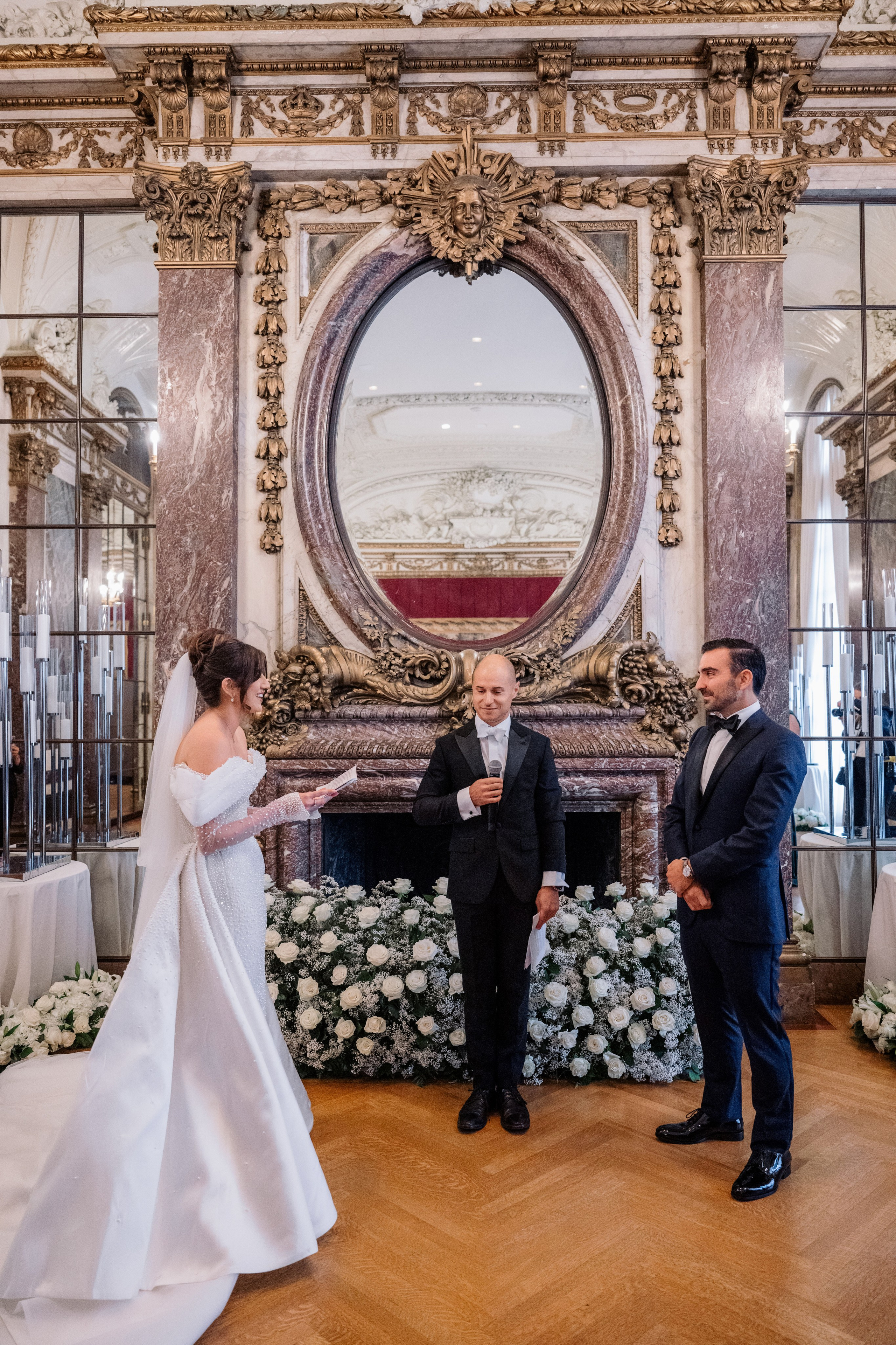 a bride and groom standing in front of a mirror