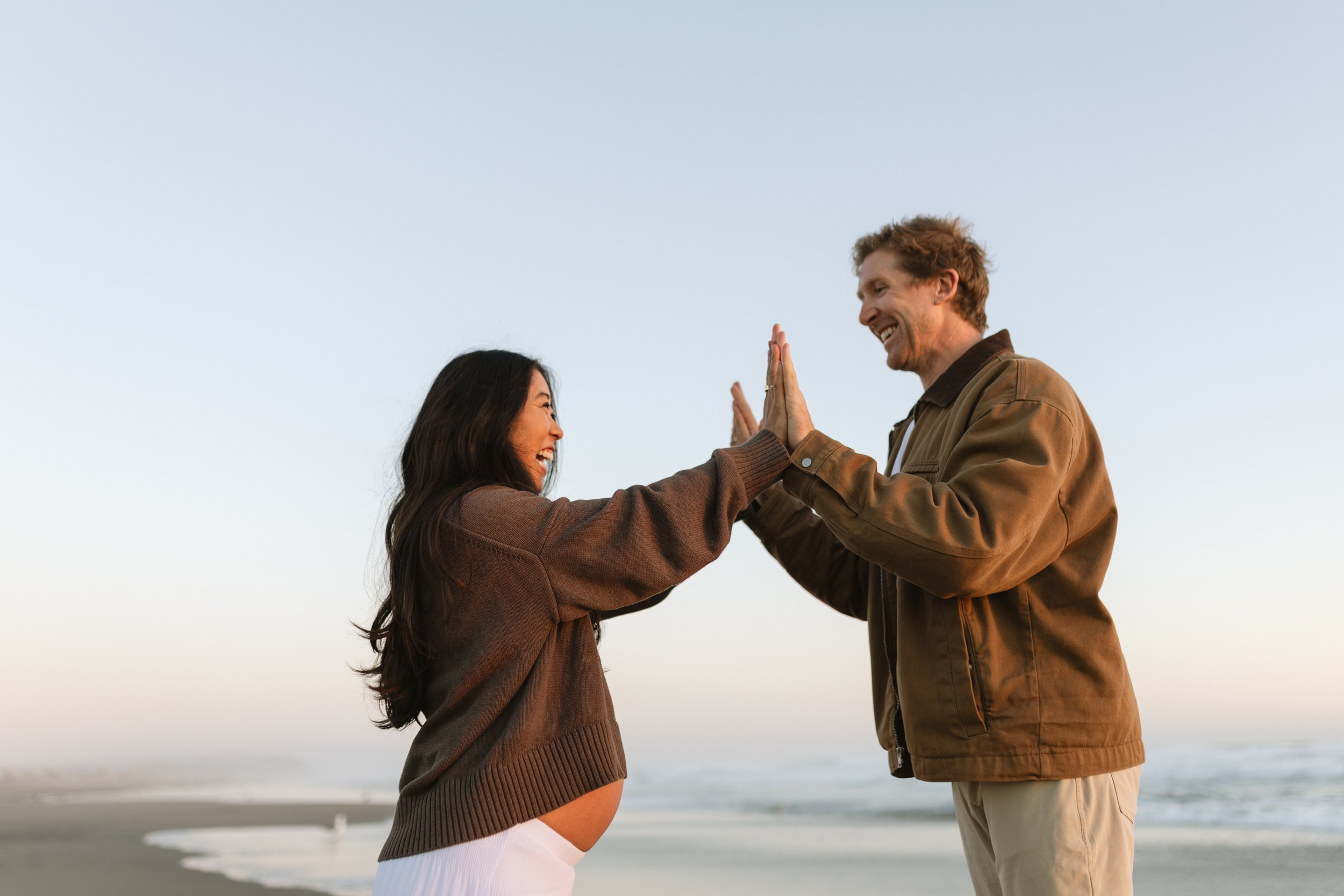Expecting parents enjoying sunset on Ocean Beach in San Francisco