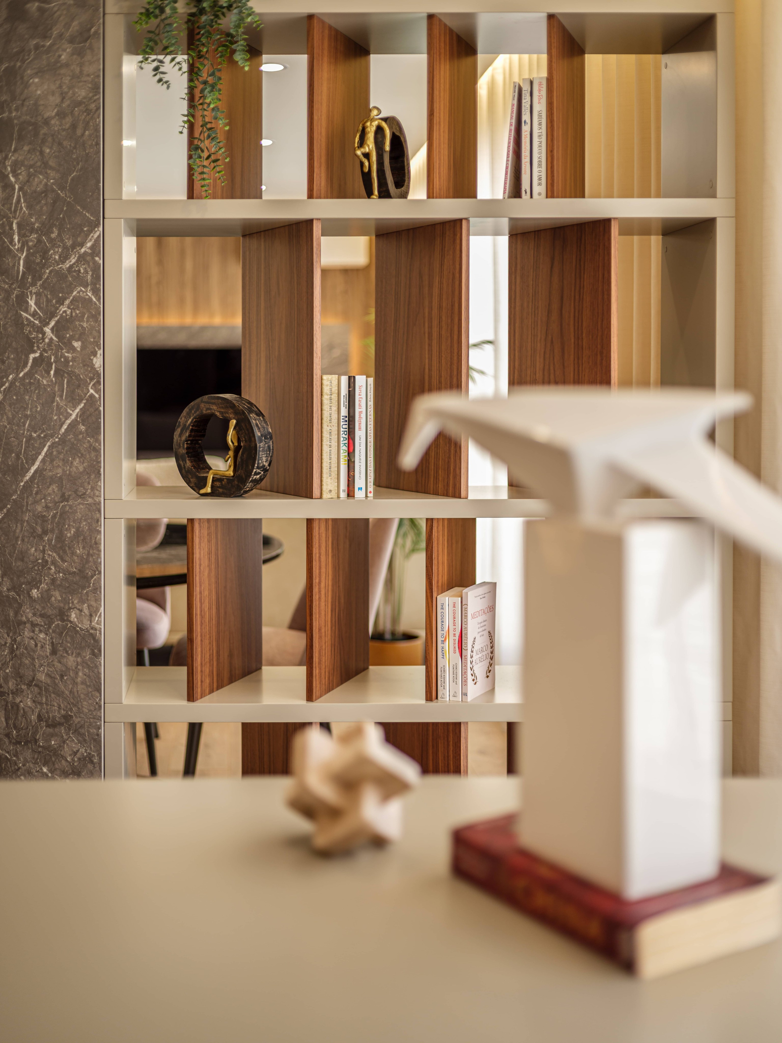 fotografia interiores de detalhe de estante em escritório que funciona como divisória para sala estar