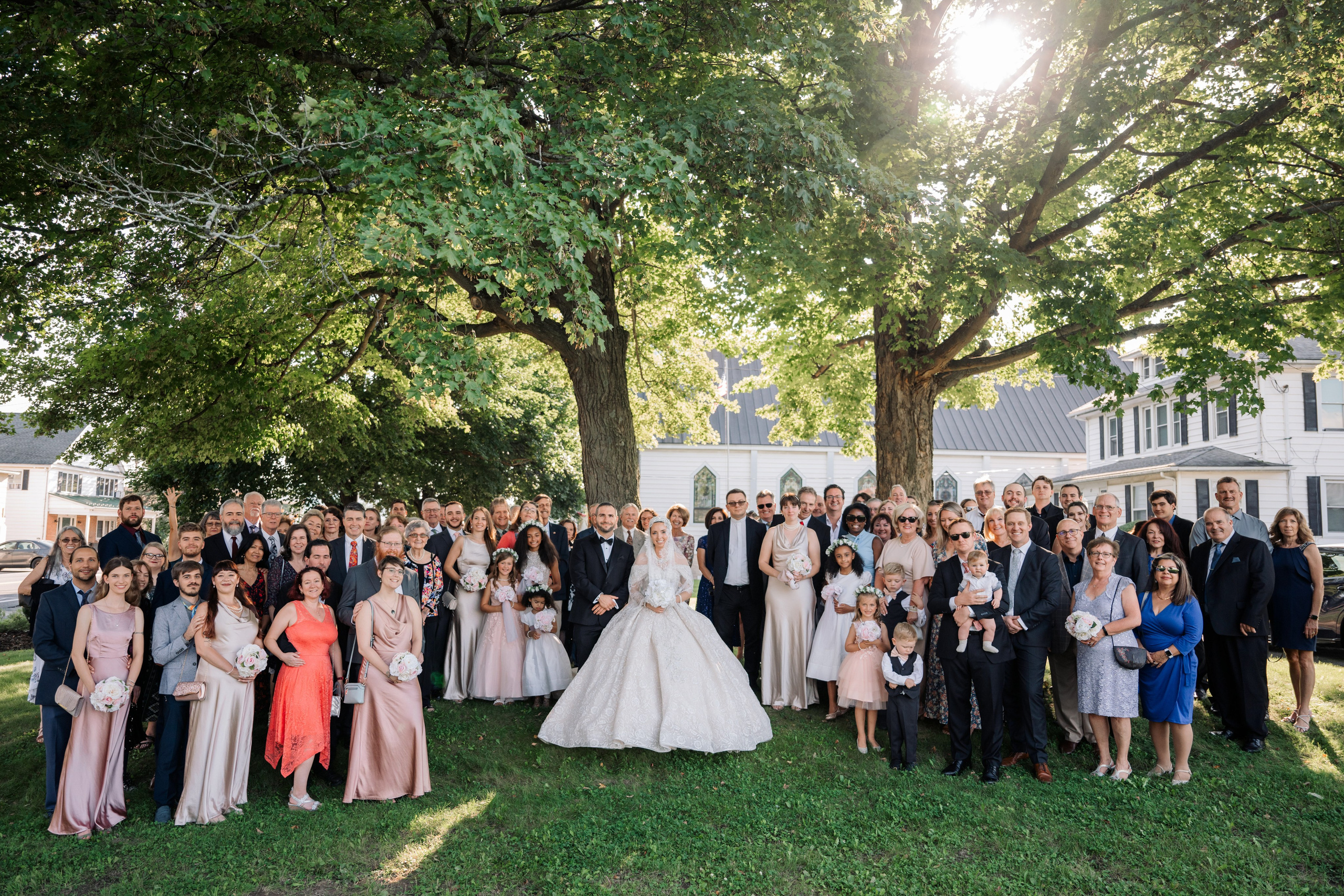a group of people posing for a photo in front of a tree