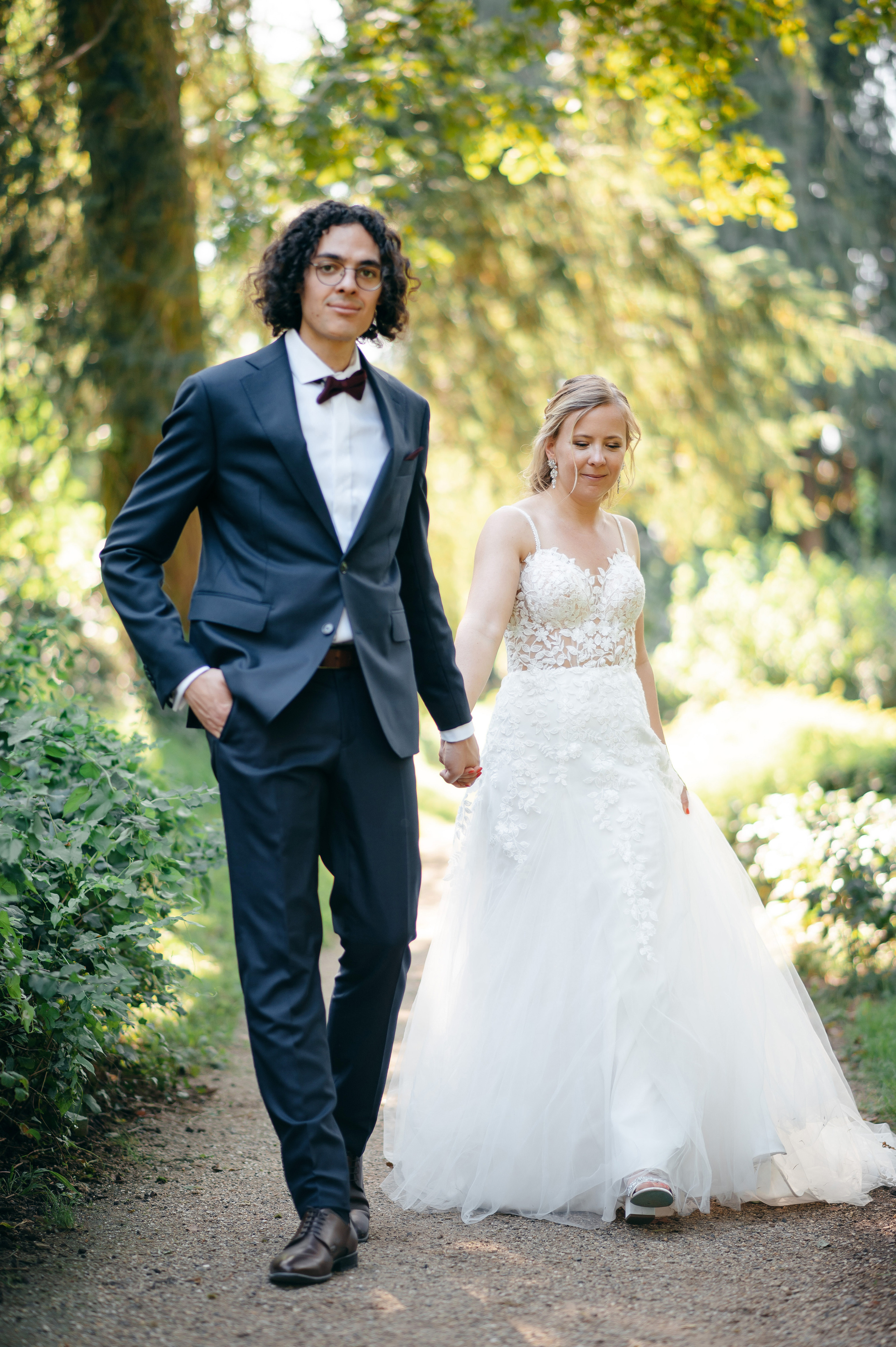 Hochzeitspaar zwischen alten Wegen und Grünflächen am Schloss