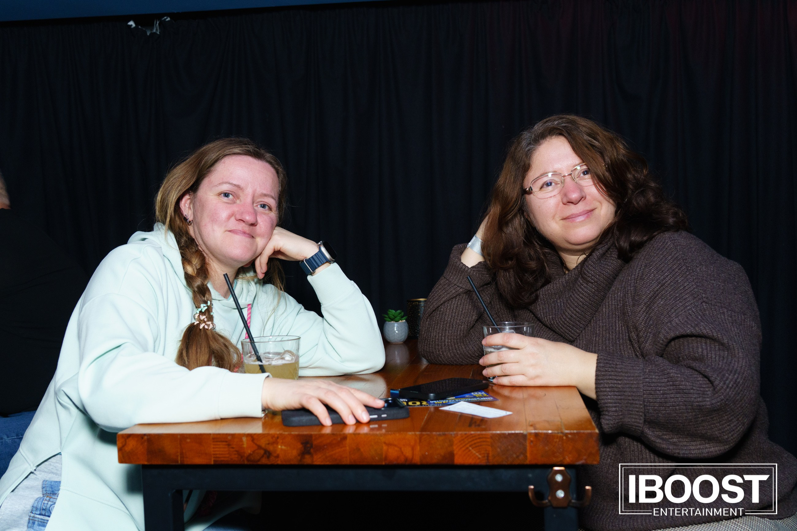 Two women sitting at a wooden table during the Animal JazZ concert in Sofia.