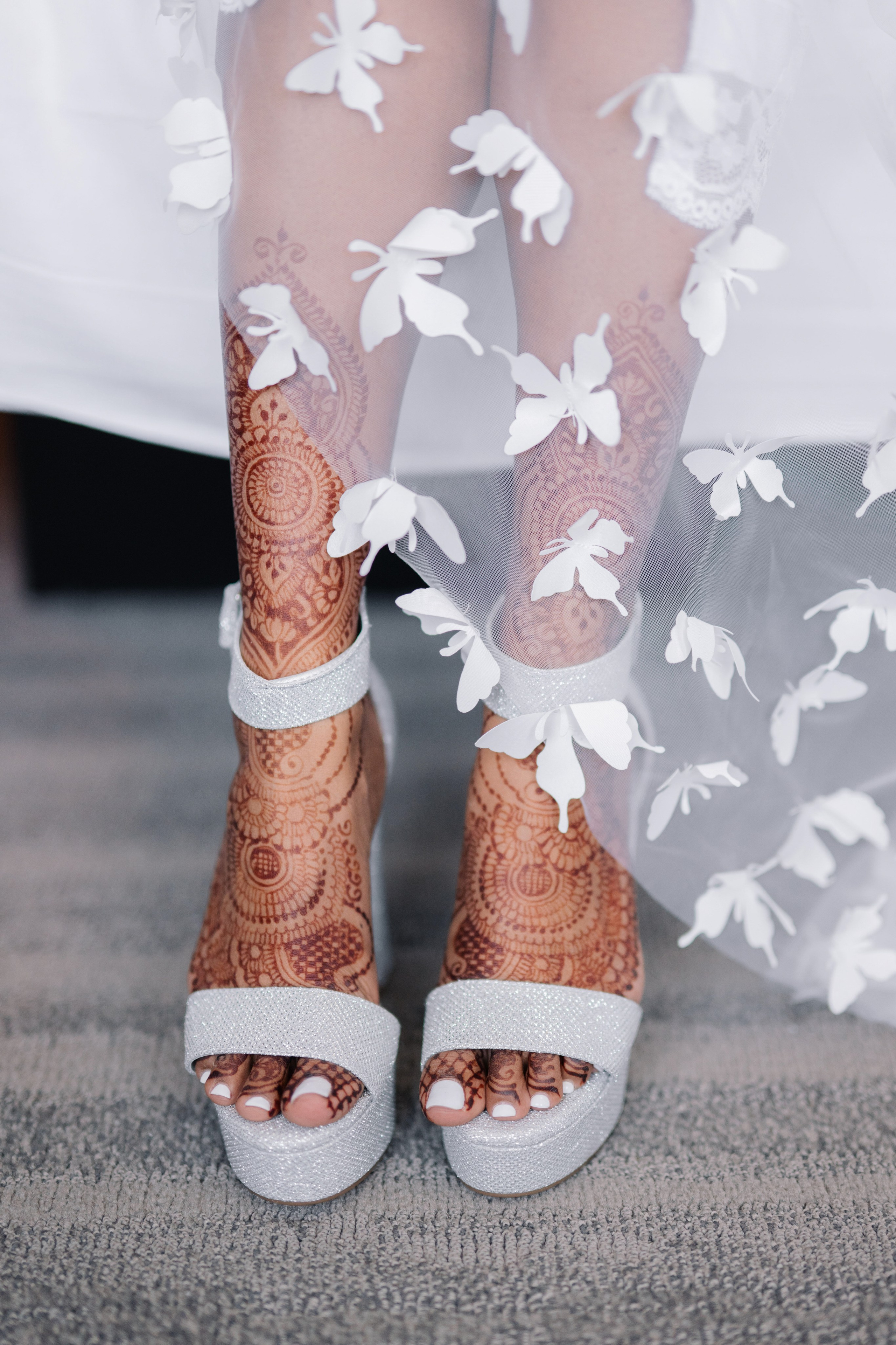 a bride's feet with white flowers on them