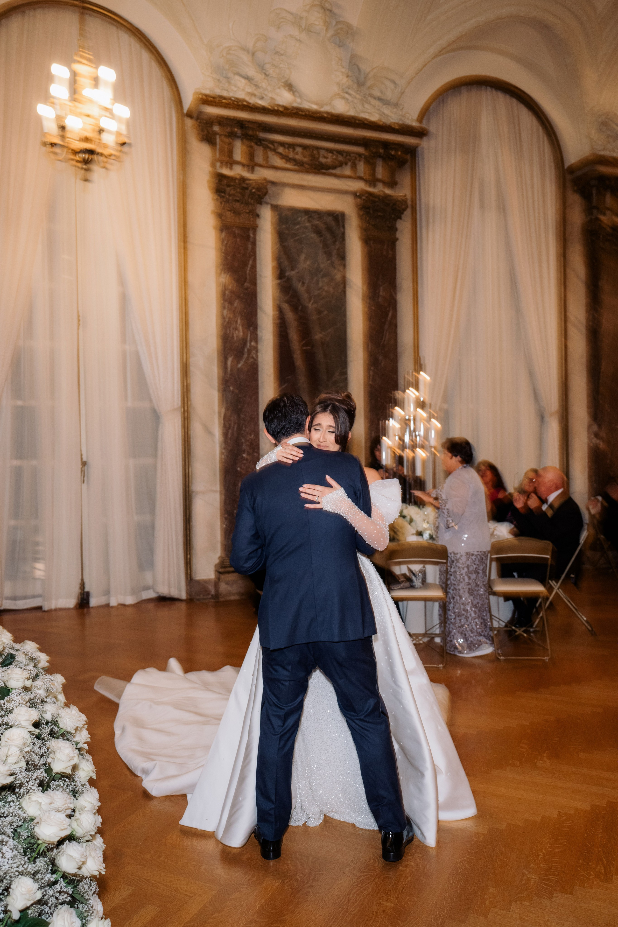 a bride and groom hug in a ballroom