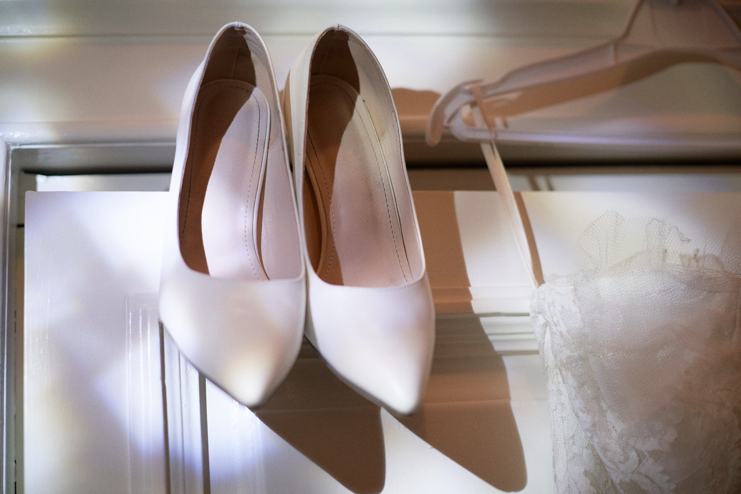 Stylish black wedding heels on photo frame in moody Prague suite.