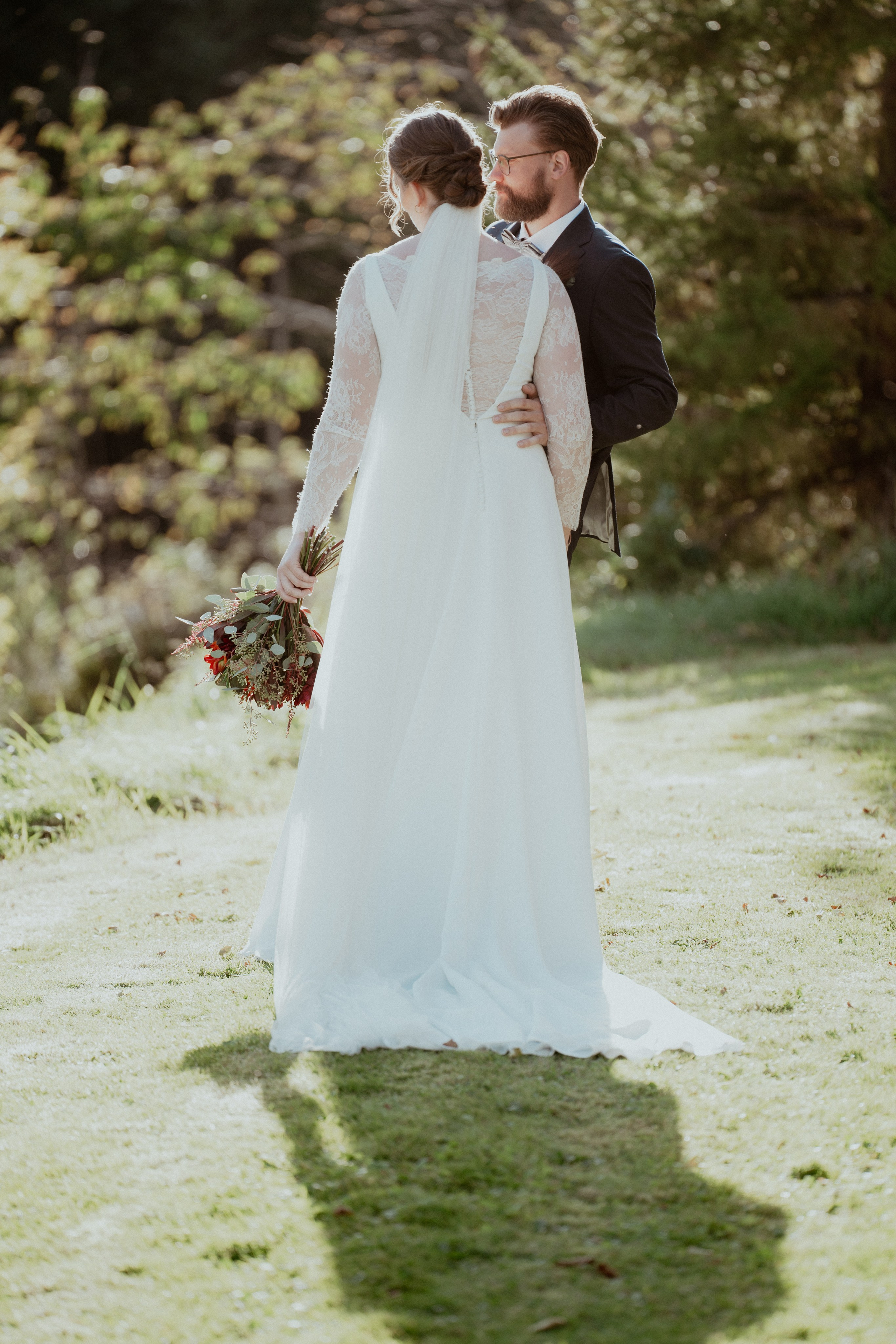 Det vakre brudeparet står ved siden av hverandre og ser på hverandre en sensommerdag