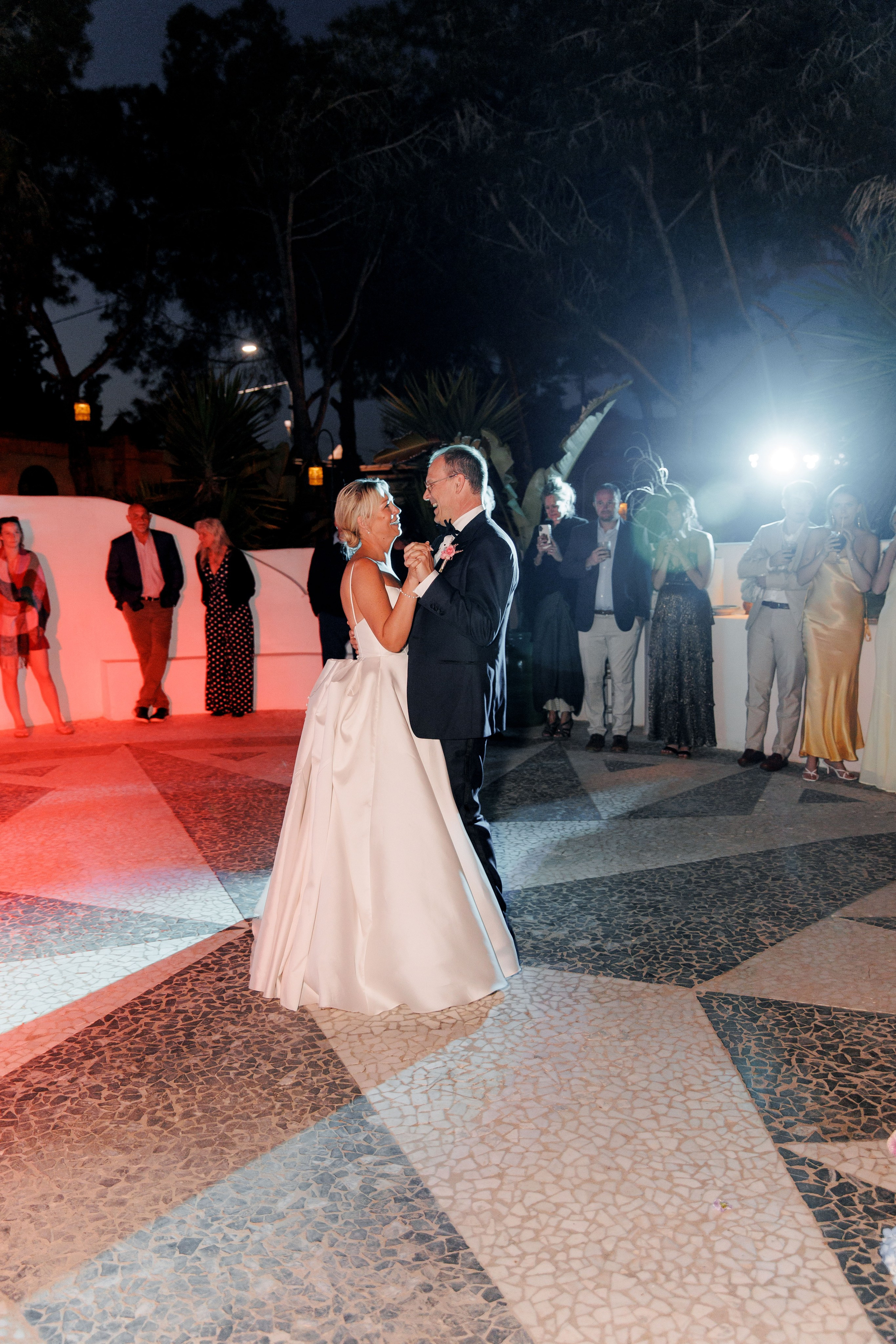 The bride and groom share their first dance surrounded by loved ones at the Gran Villa Rosa reception.